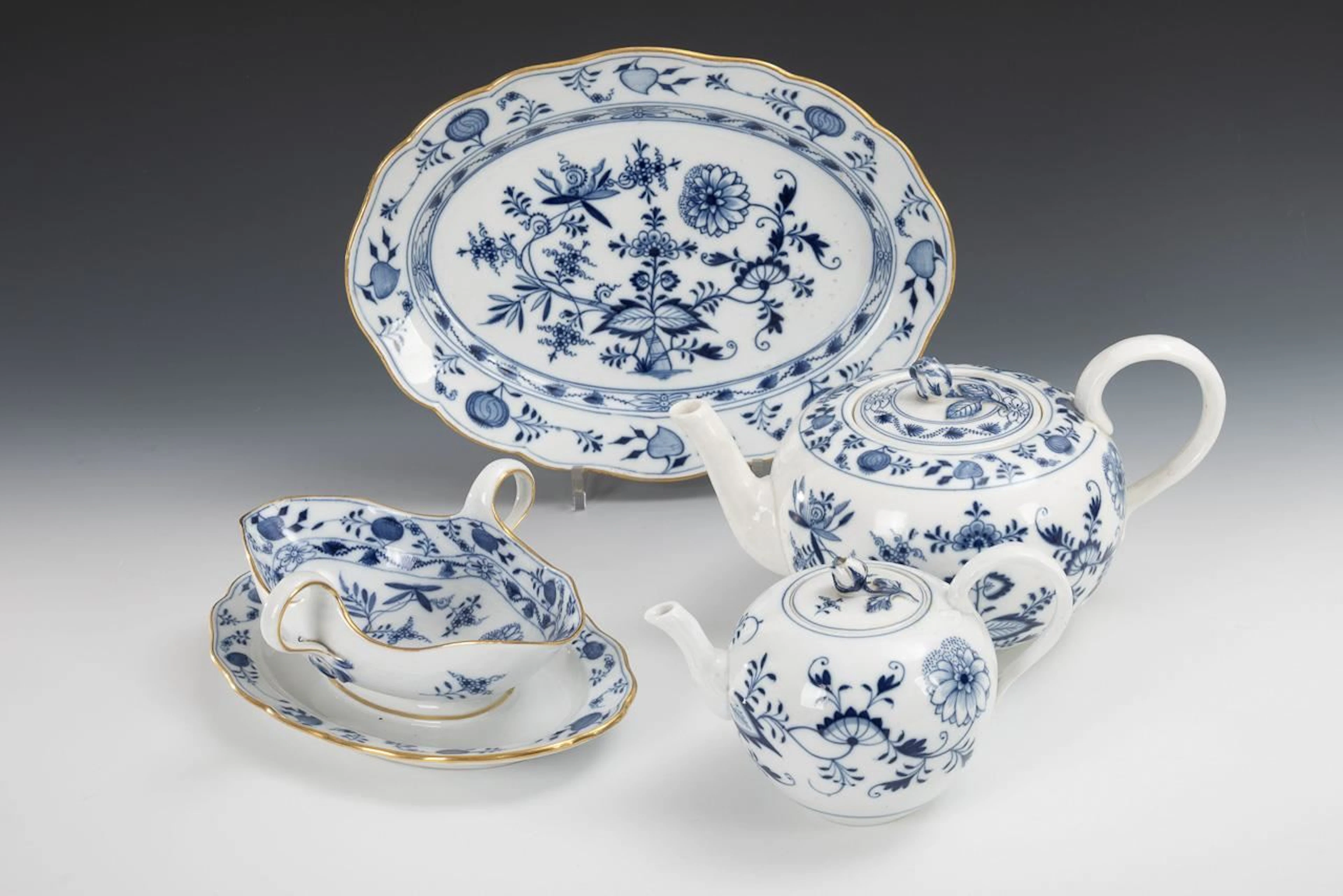 2 onion-pattern teapots, saucers, and oval plates. Meissen.