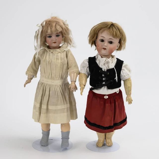 2 blonde porcelain-headed dolls.
