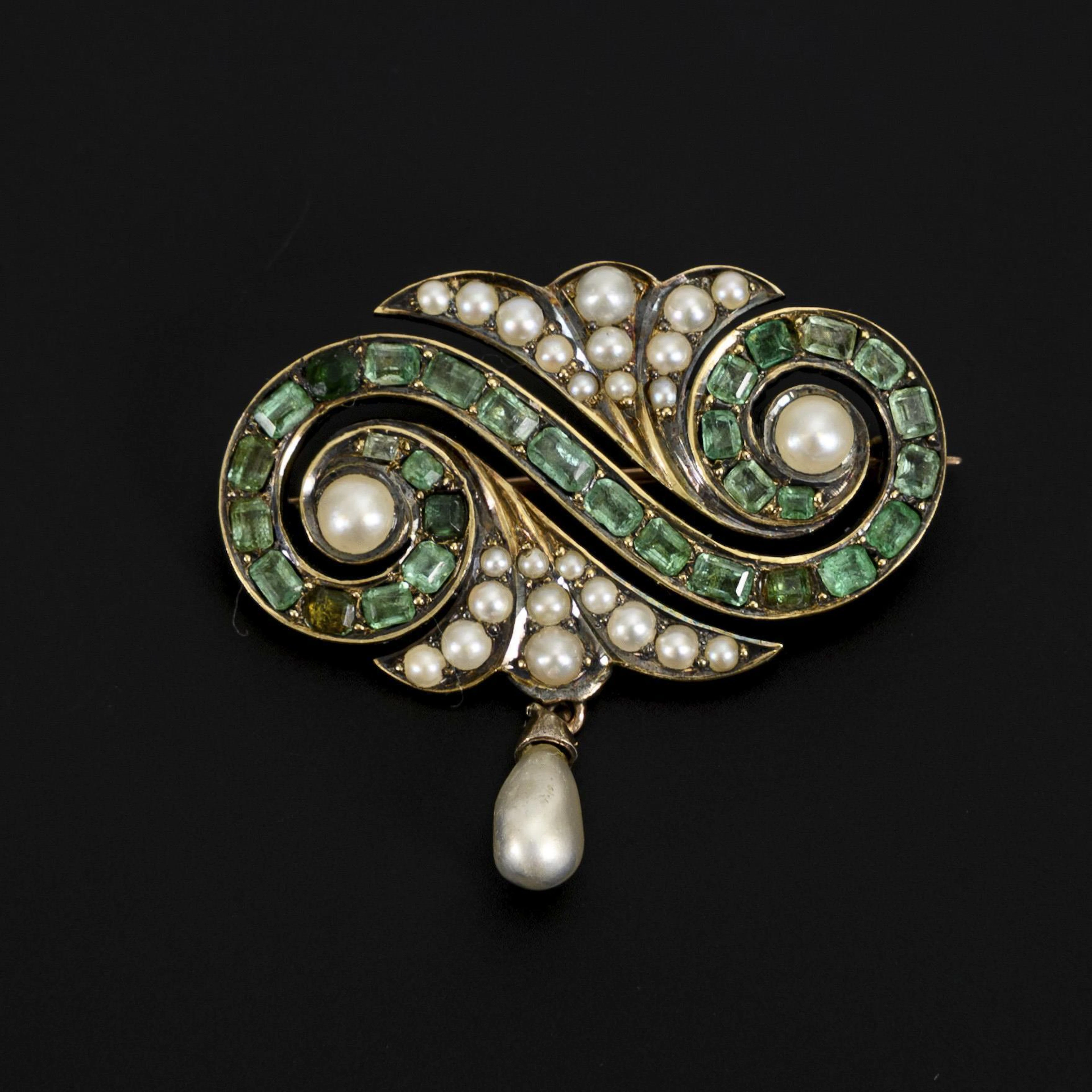 Historical brooch with green colored stones and pearls.