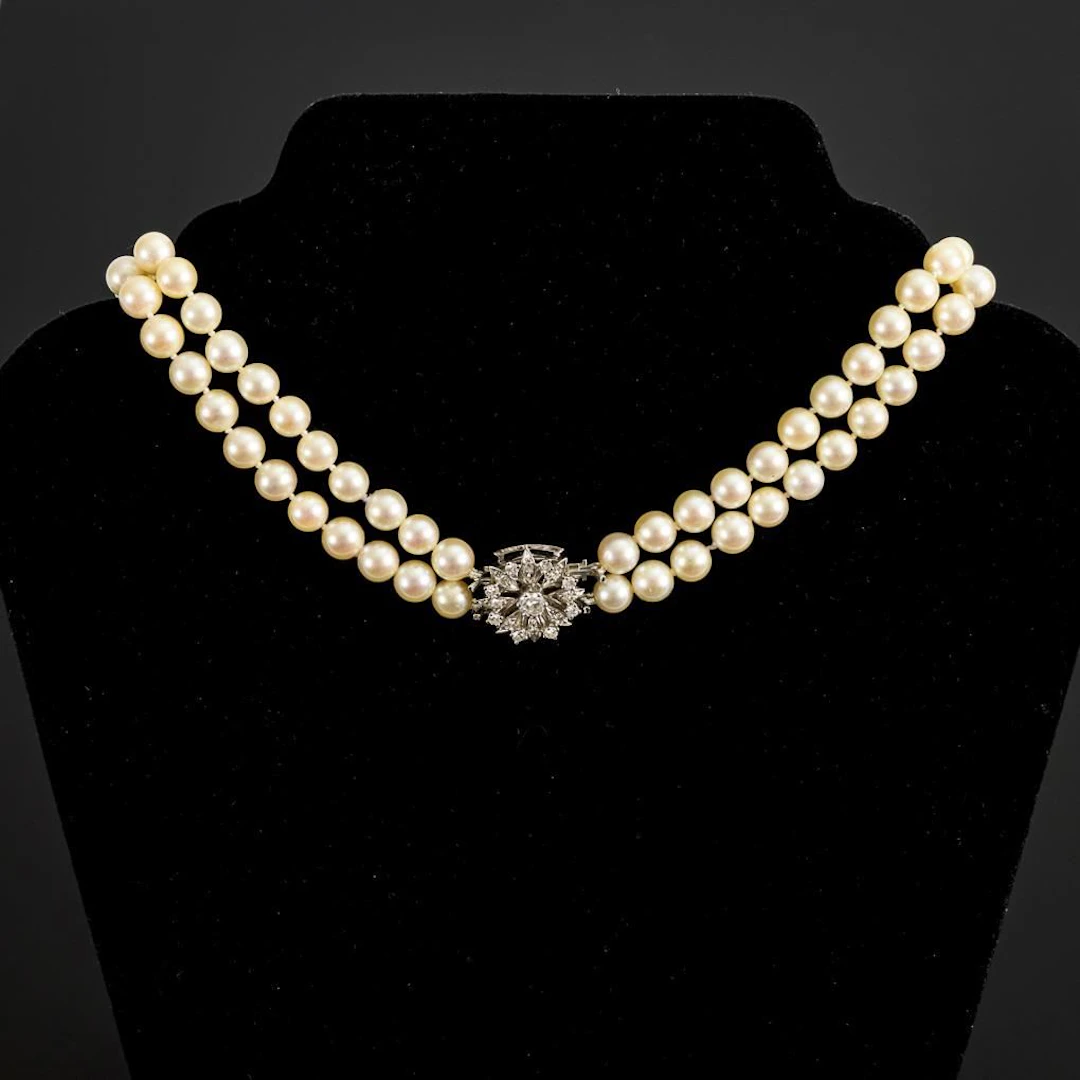 Double-row pearl necklace with a flower-shaped white gold clasp.