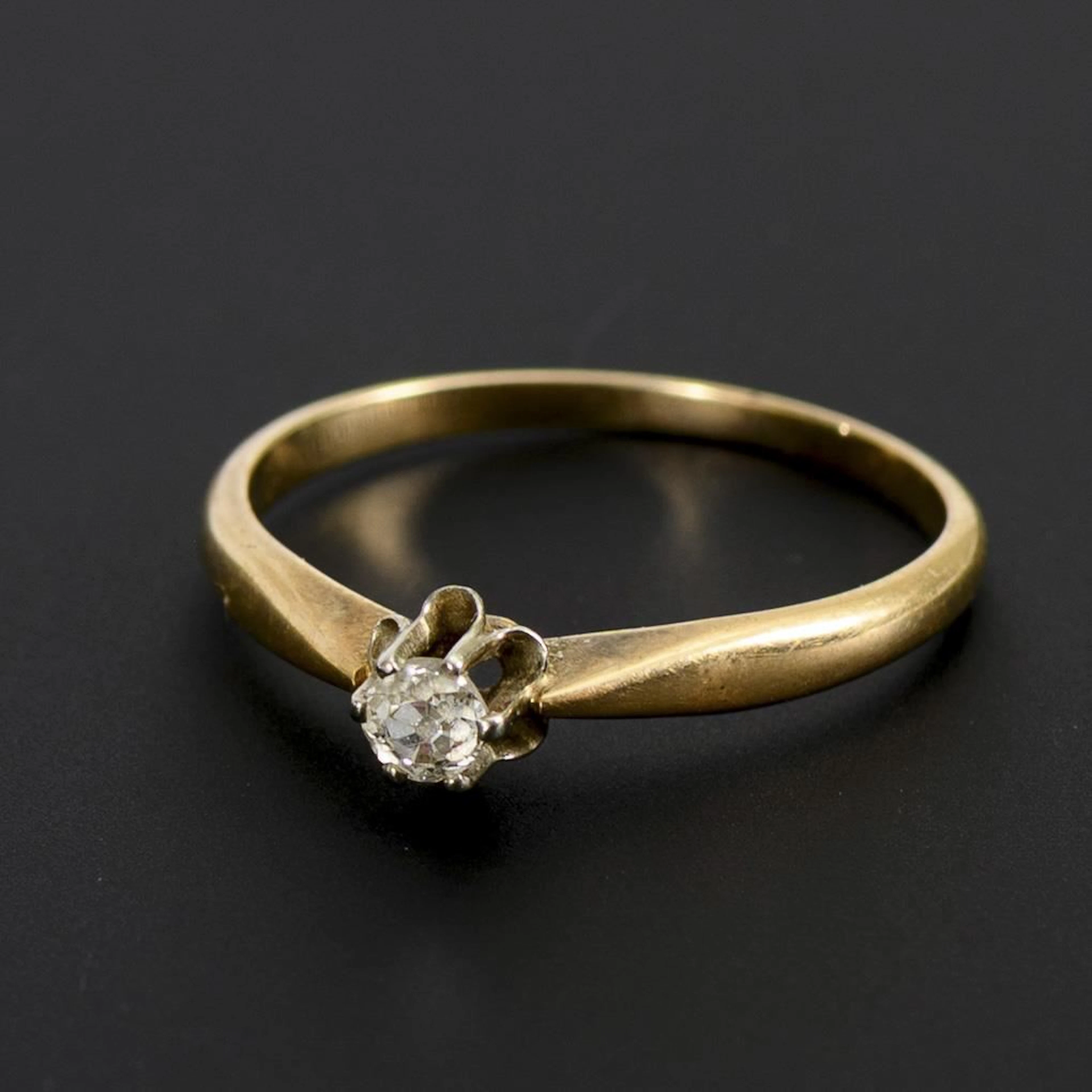 Ring with a small old-cut solitaire.