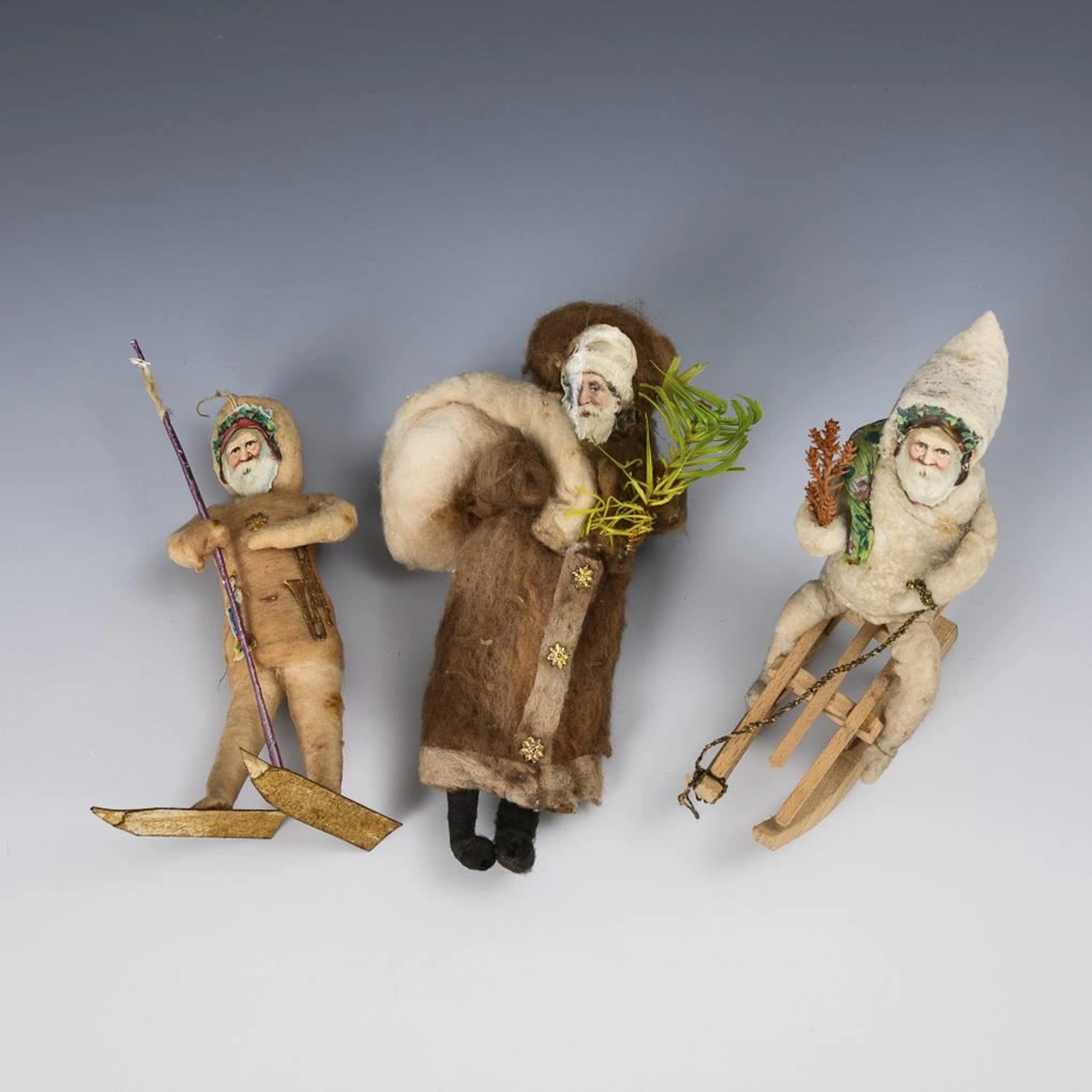 3 cotton figures dressed as Santa Claus.