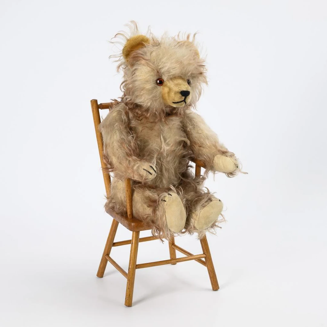 Teddy bear with brushed mohair fur, sitting on a small chair. Hermann