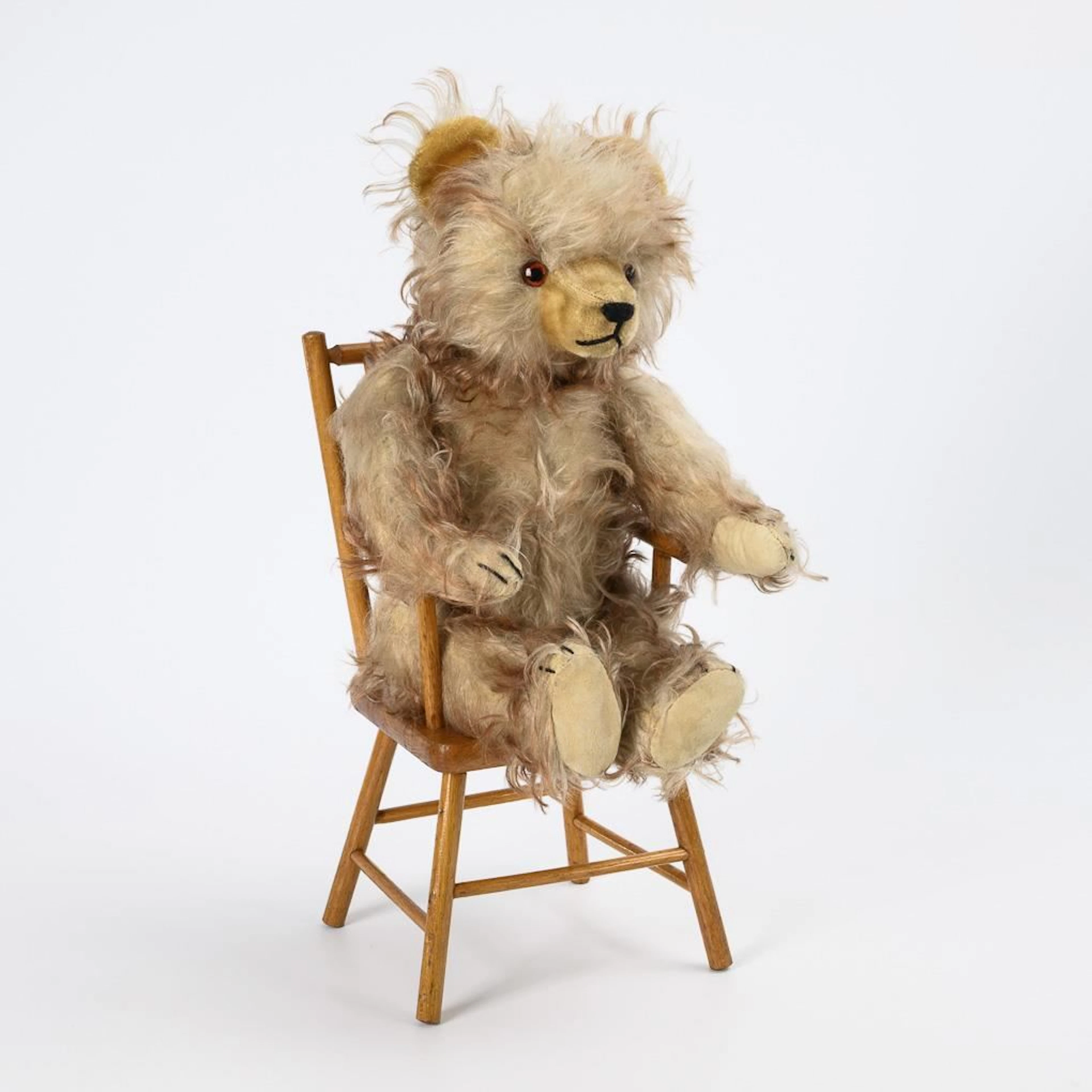 Teddy bear with brushed mohair fur, sitting on a small chair. Hermann