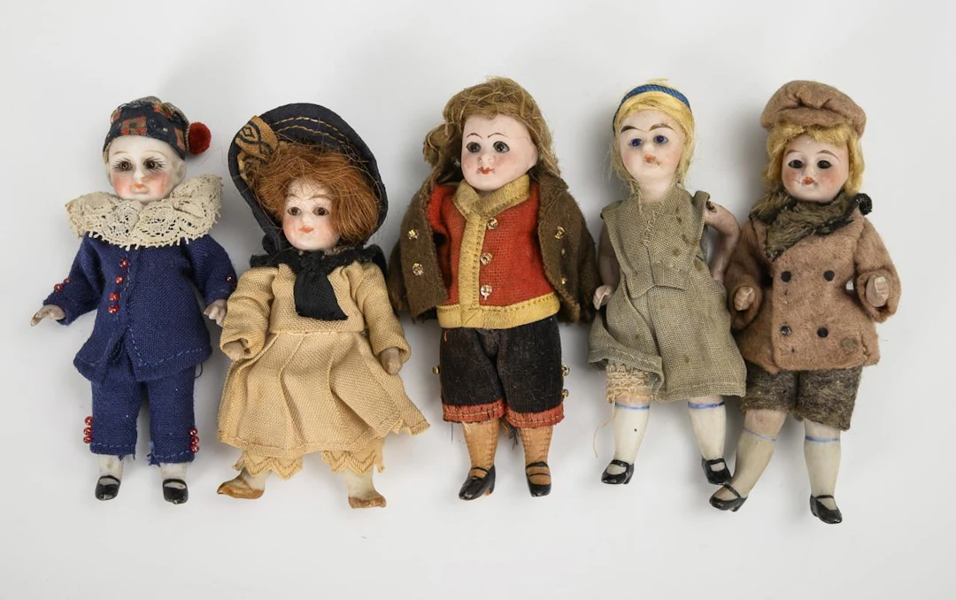 5 dollhouse dolls with glass eyes.