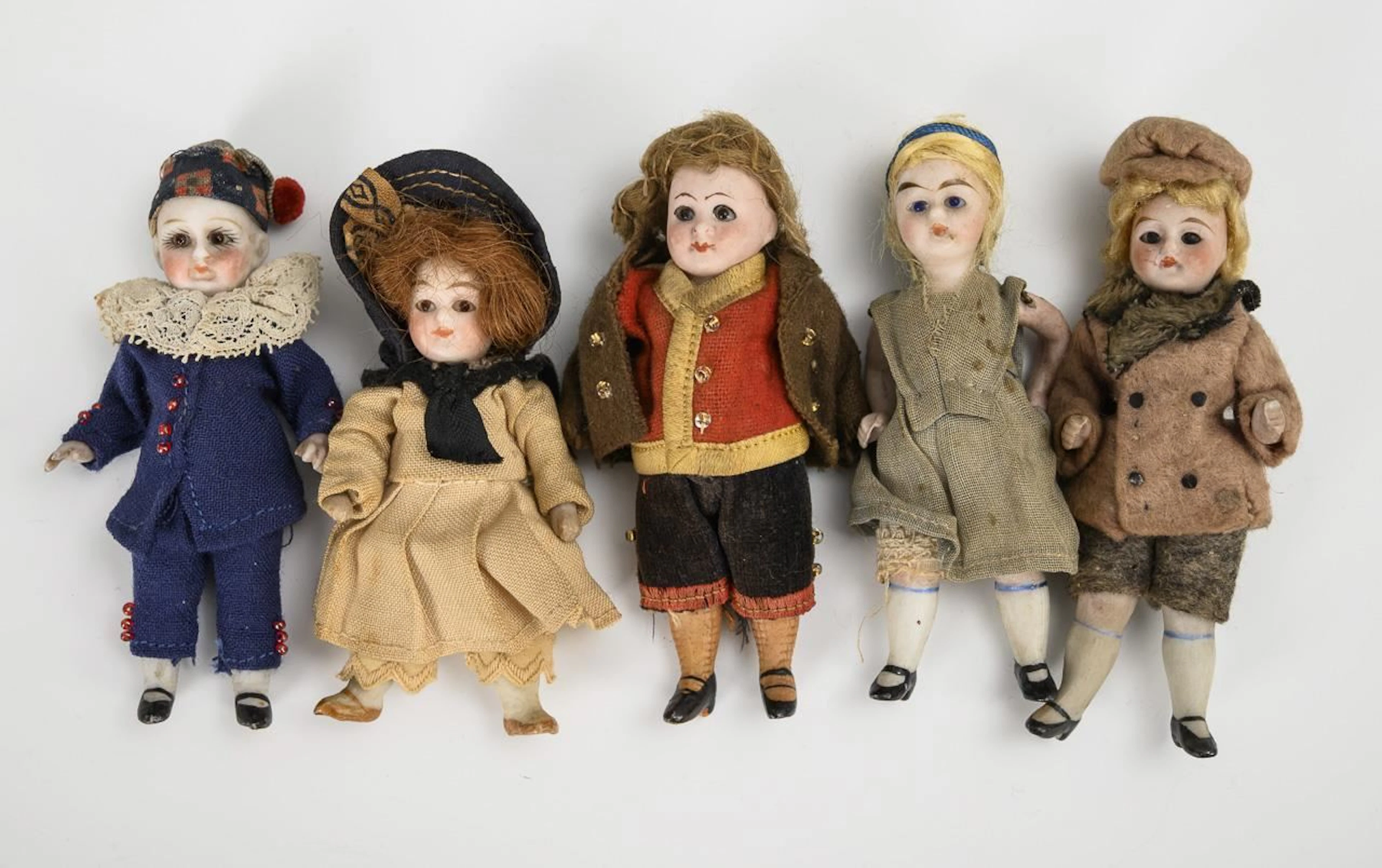 5 dollhouse dolls with glass eyes.