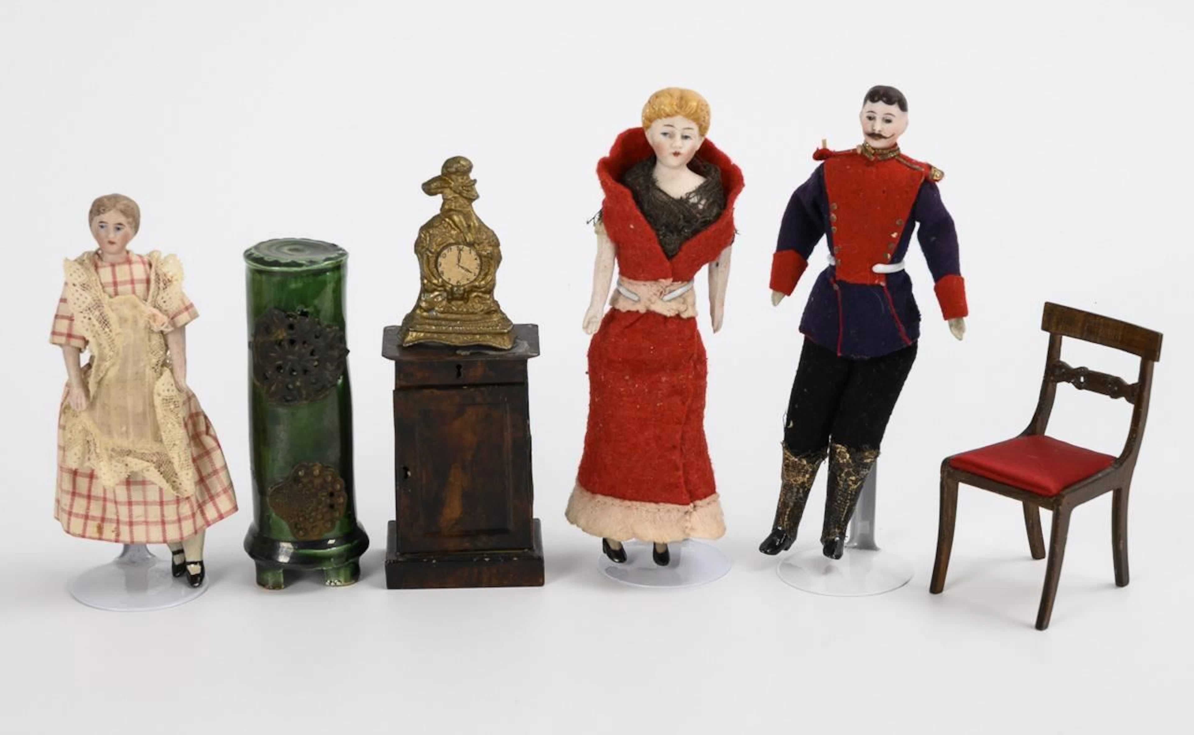 Dollhouse set: 3 small bust-head dolls, a green stove, and furniture.