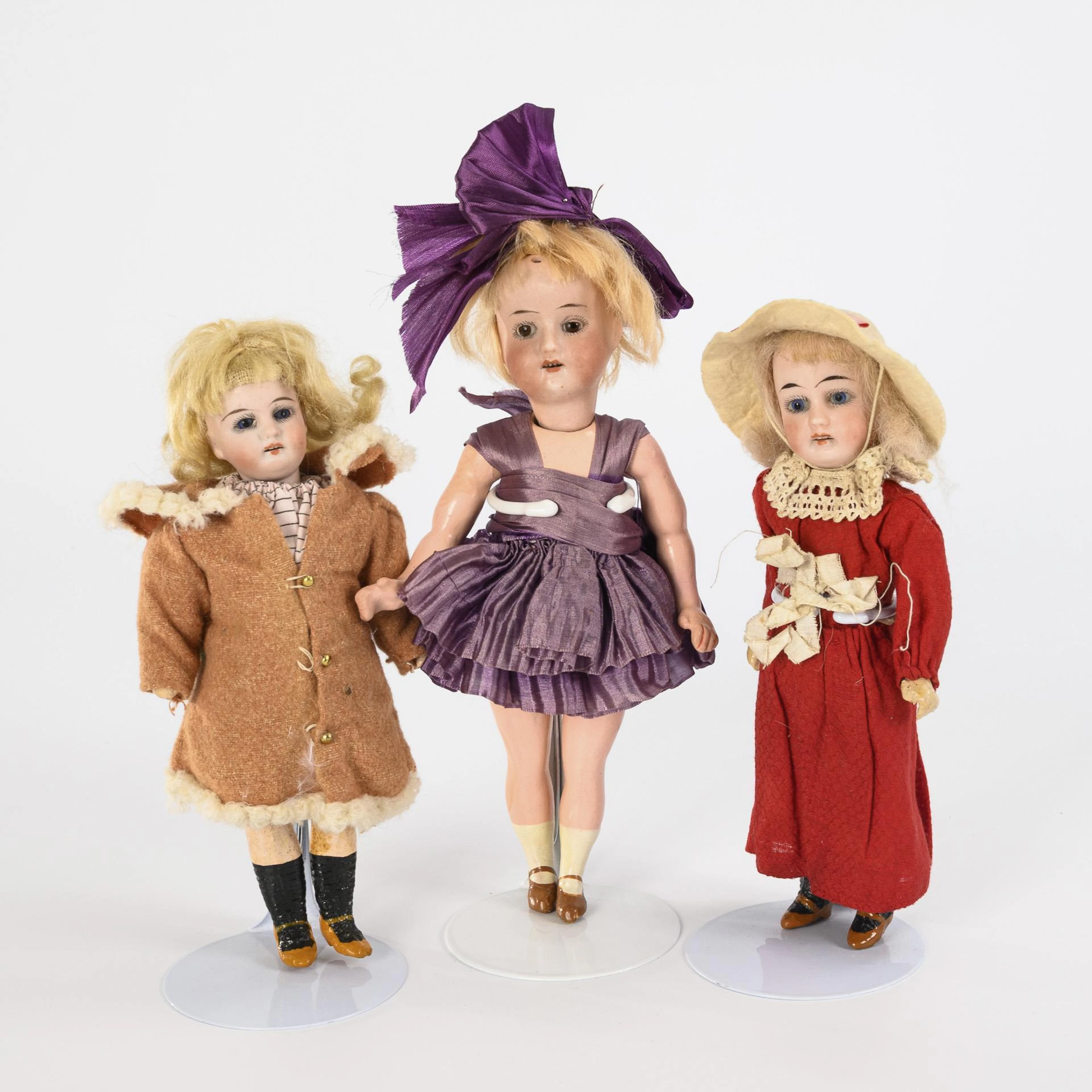 3 small, old clothed porcelain head dolls.