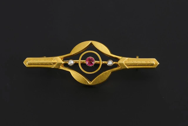 Art Nouveau brooch with a red gemstone or synthetic stone and small pearls.