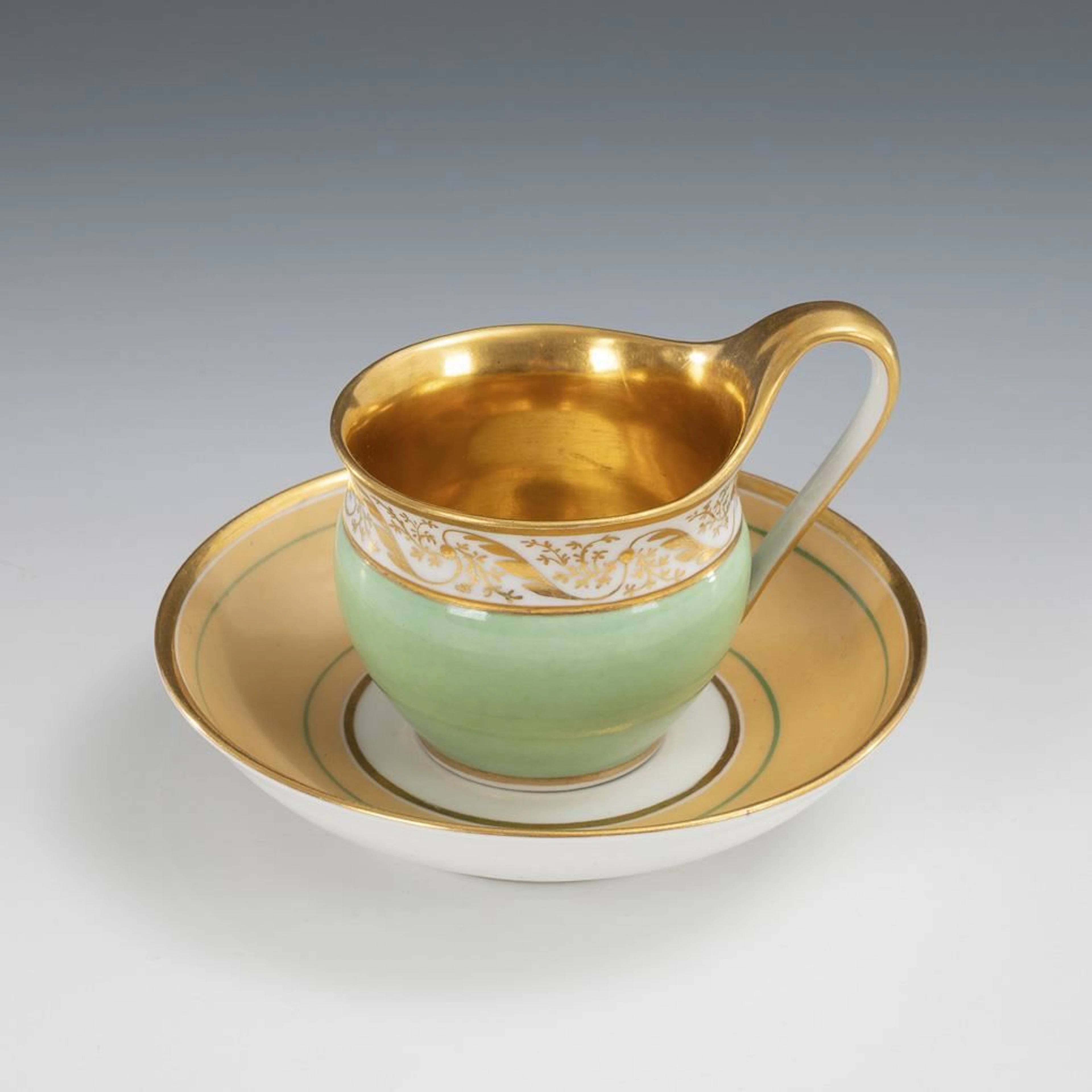 Display cup with a mint-green partial background. KPM Berlin.