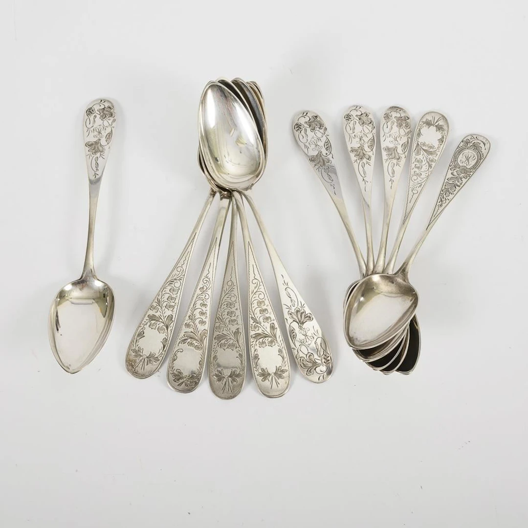 11 silver soup spoons with delicate floral engravings.