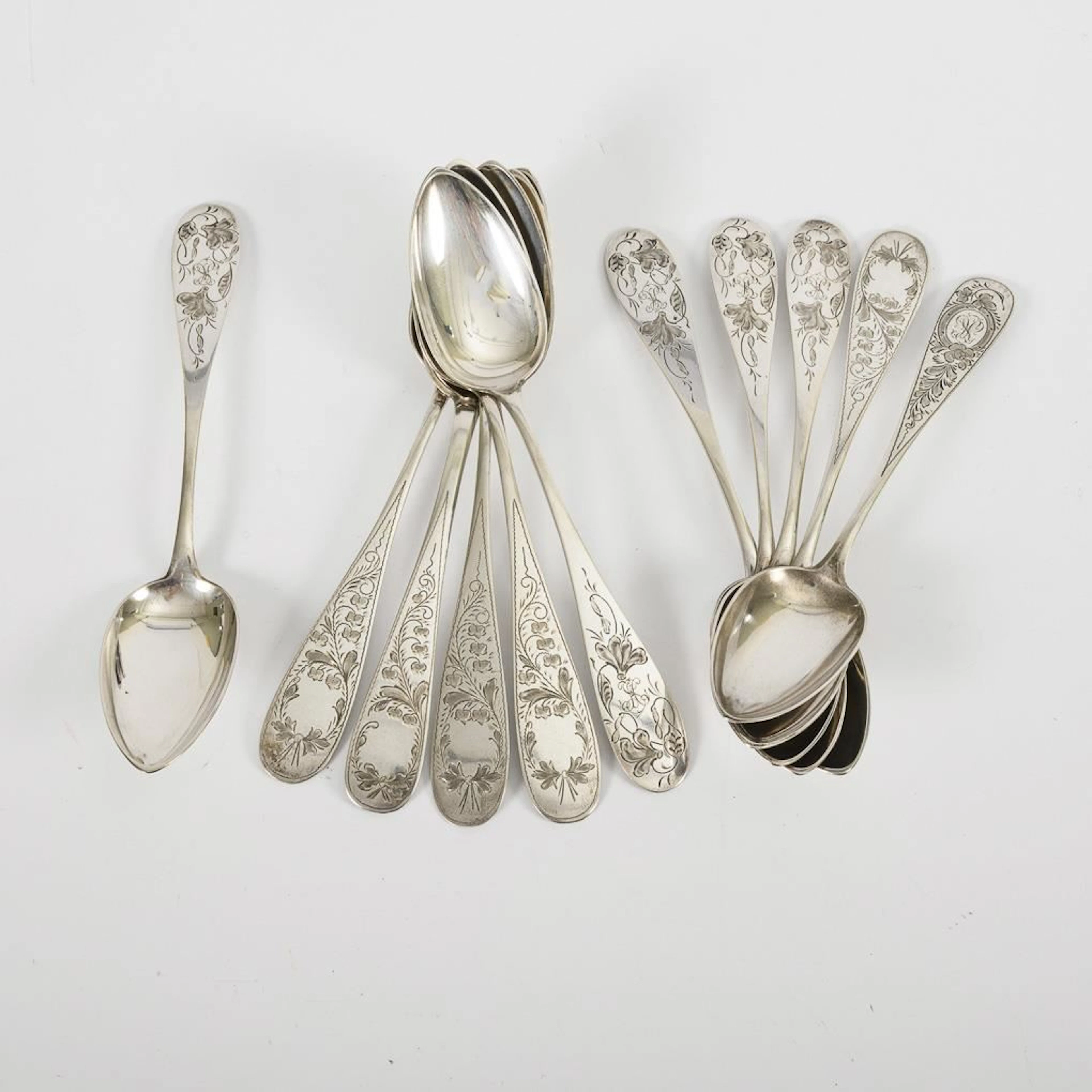 11 silver soup spoons with delicate floral engravings.