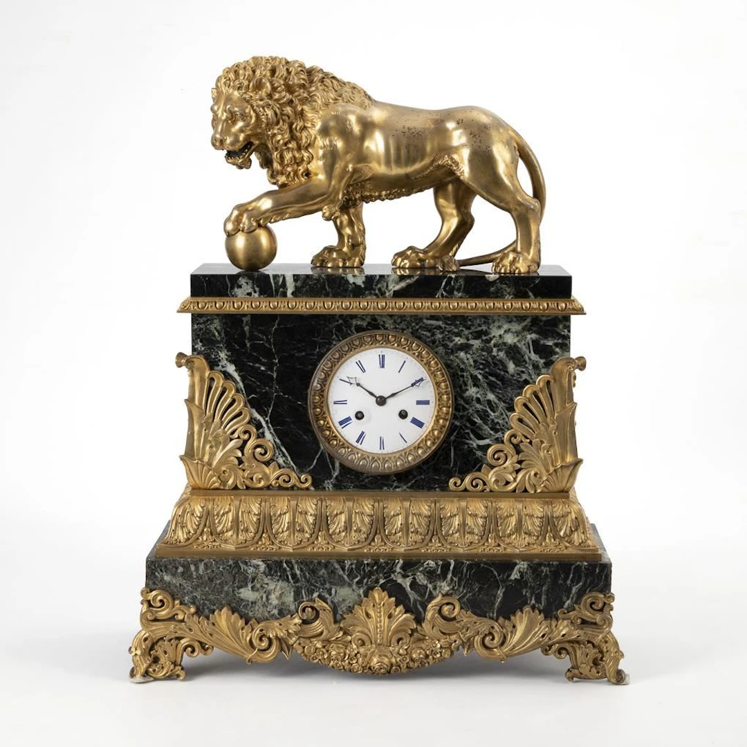 Heavy neoclassical marble pendulum clock with a lion-topped finial.