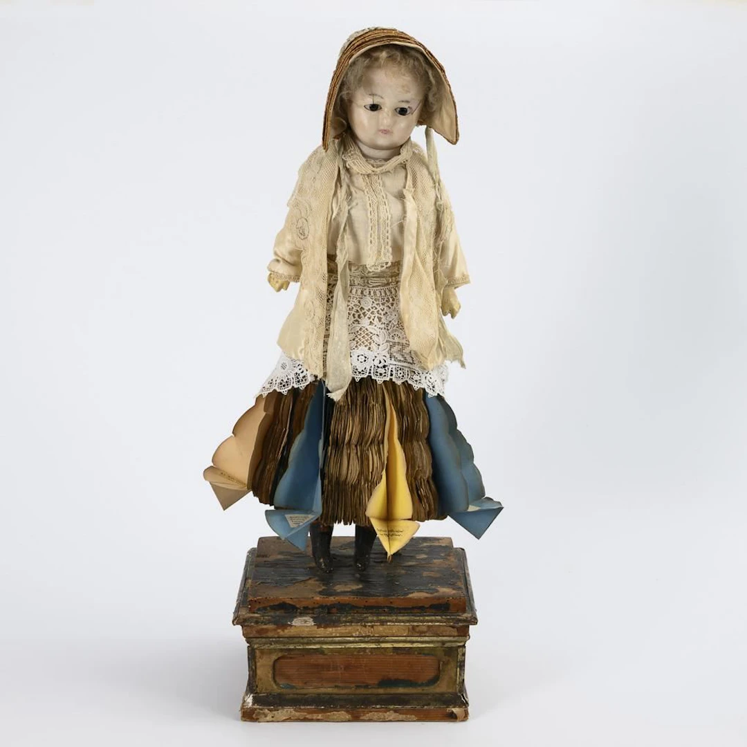 Rare "fortune-telling doll" on a wooden base.