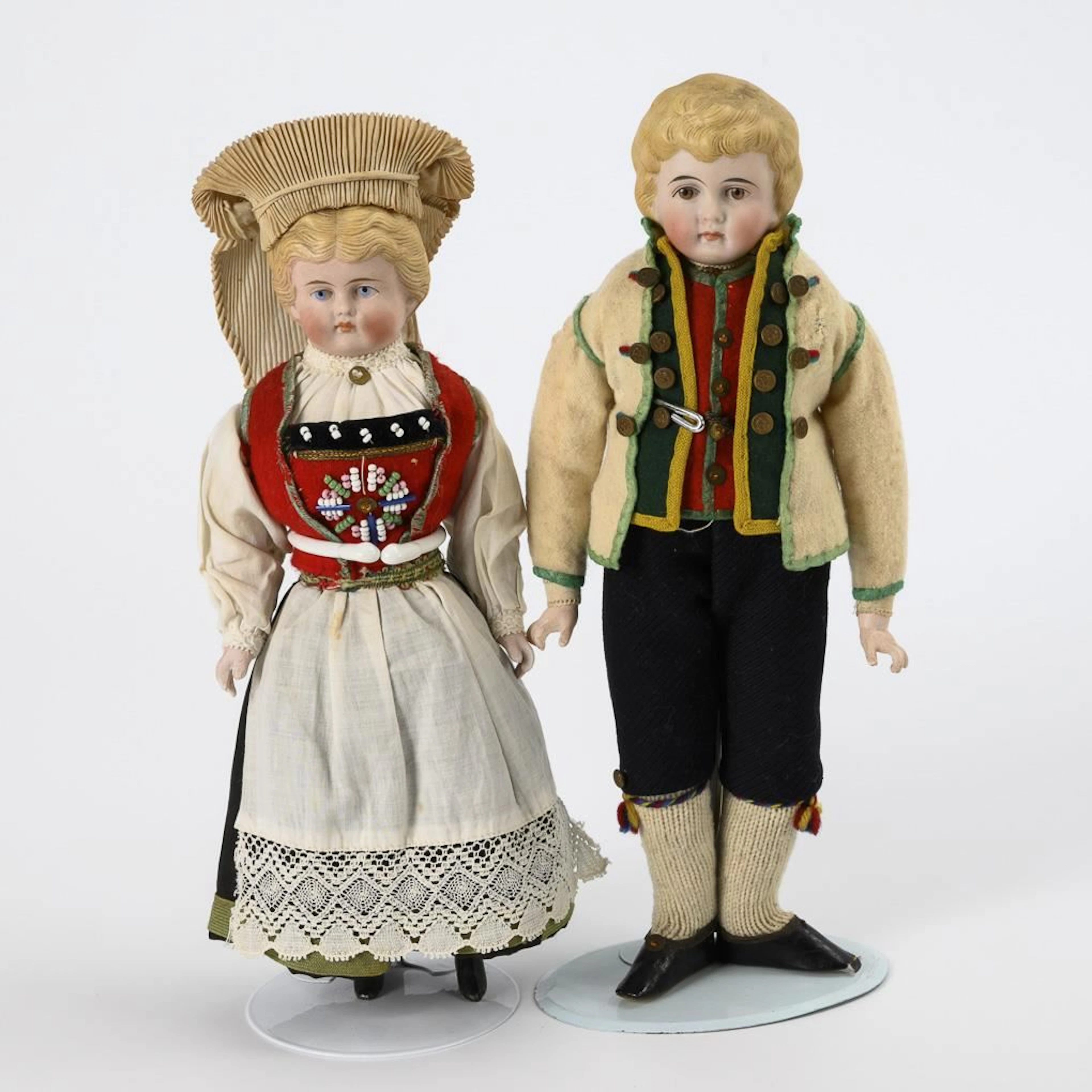 2 bust-head dolls in traditional costume.