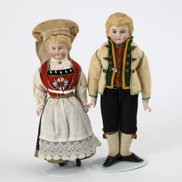 2 bust-head dolls in traditional costume.