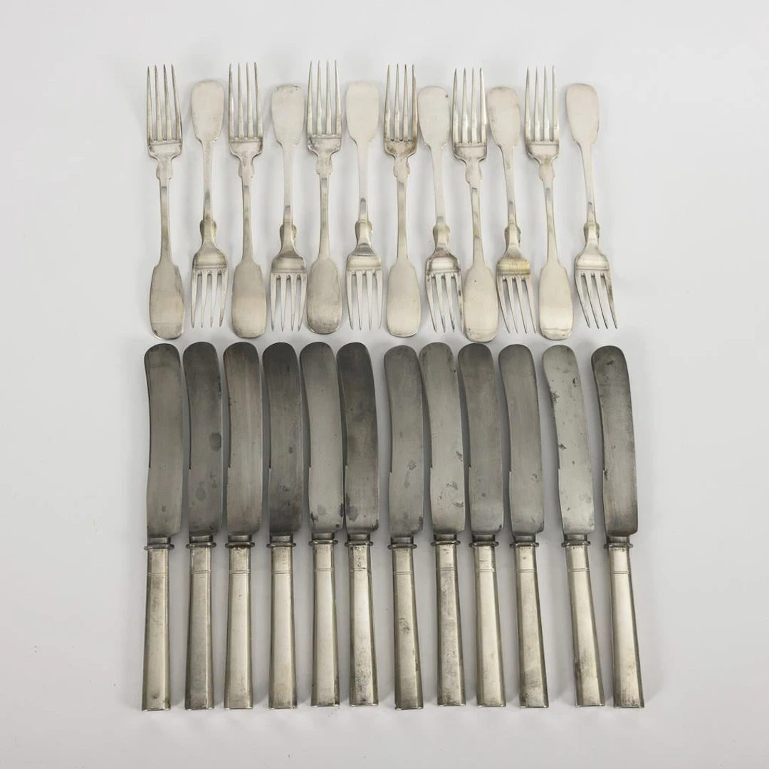 12 silver forks and 12 knives, in a black box. Hermann Walter, Halle.