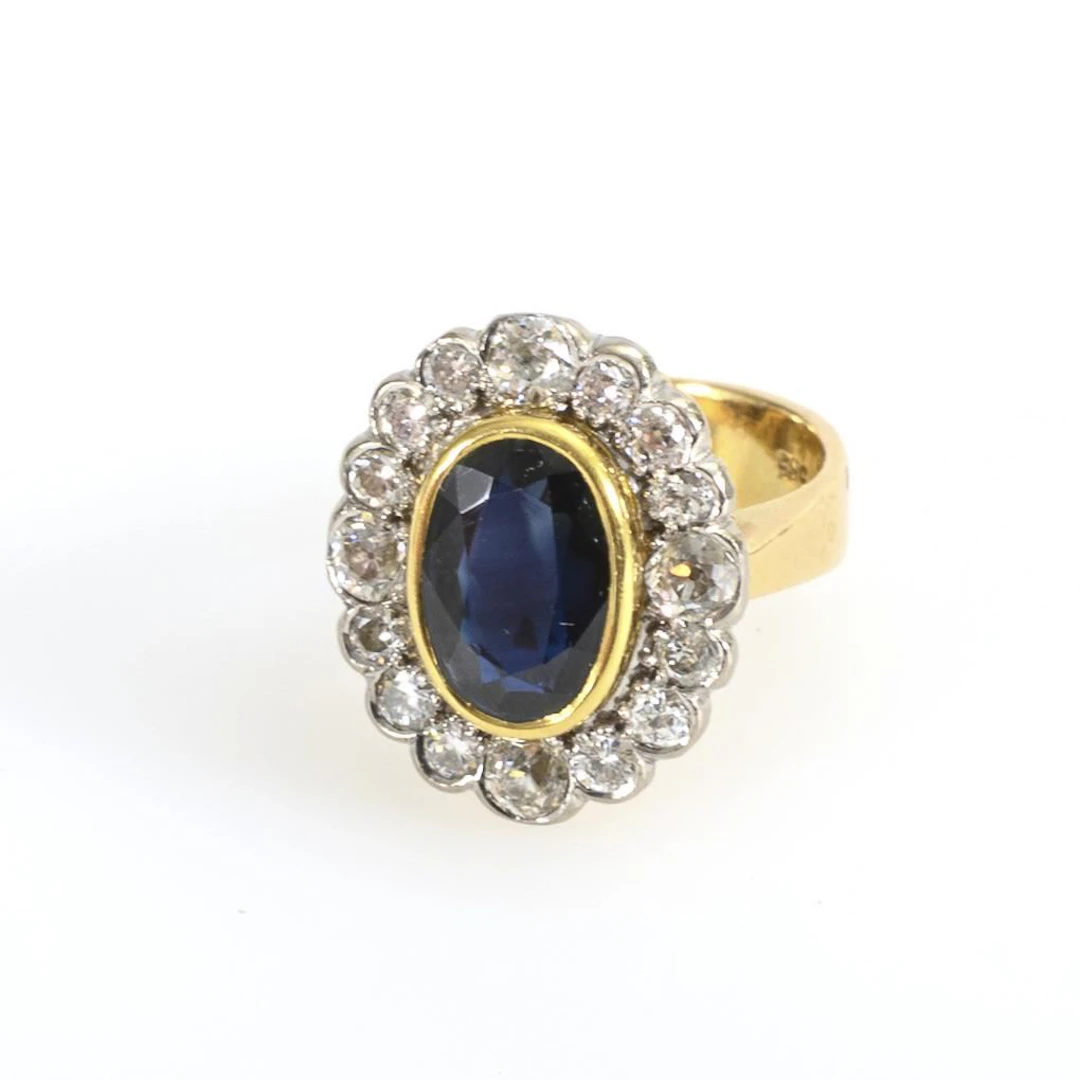 Entourage ring with a blue gemstone, likely a sapphire, and old-cut diamonds.