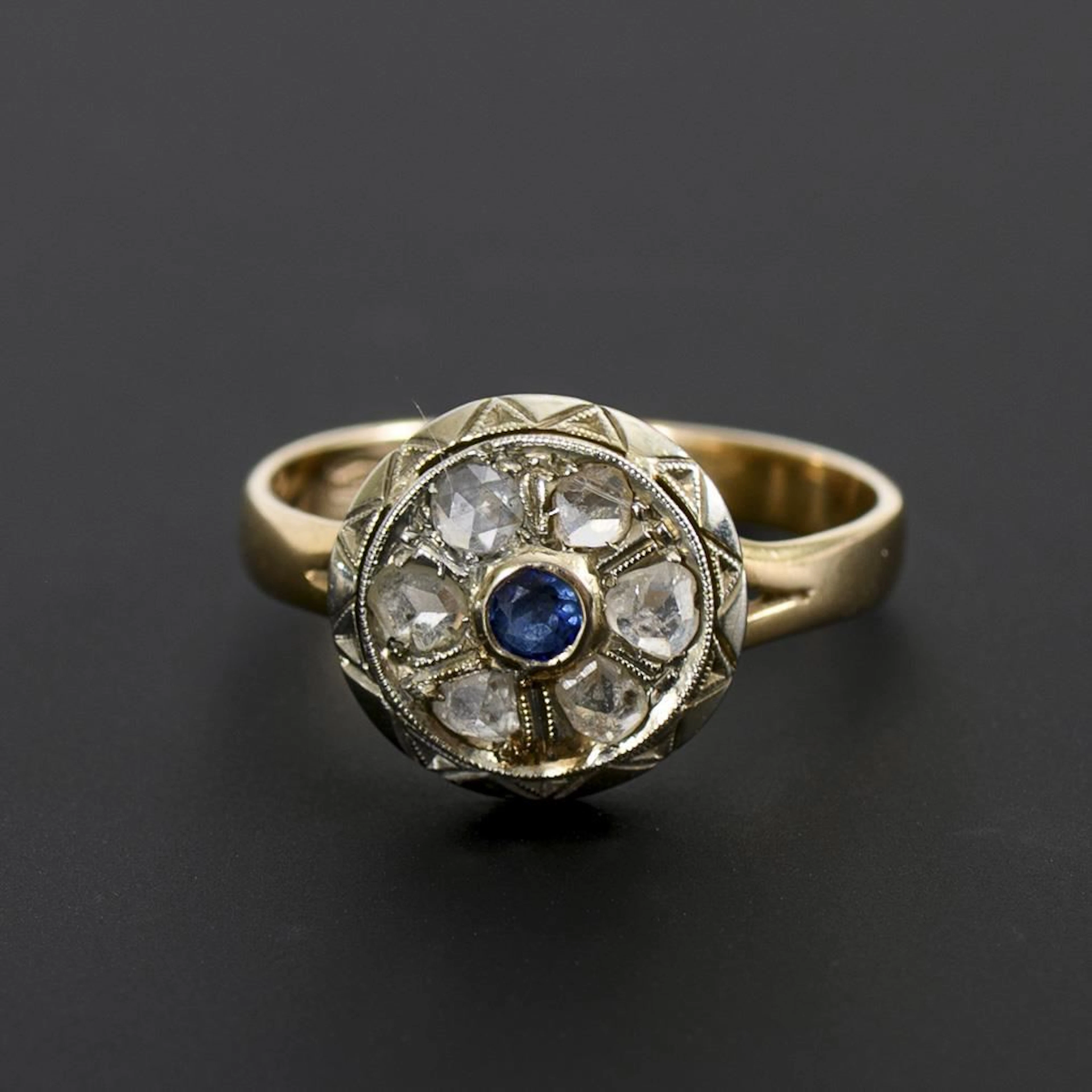 Ring with a round band, a blue gemstone, and rose-cut diamonds.