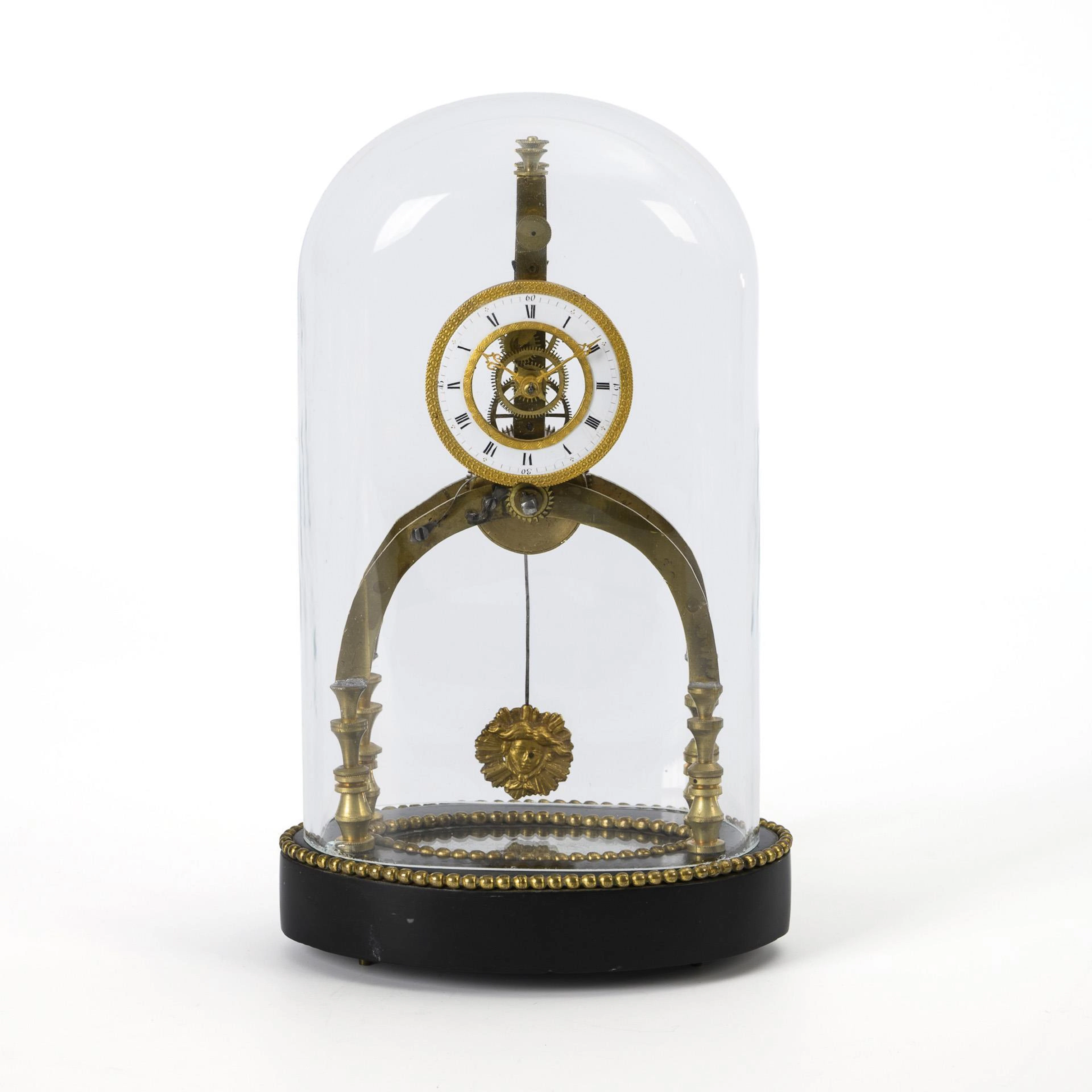Small Empire skeleton clock with glass dome.