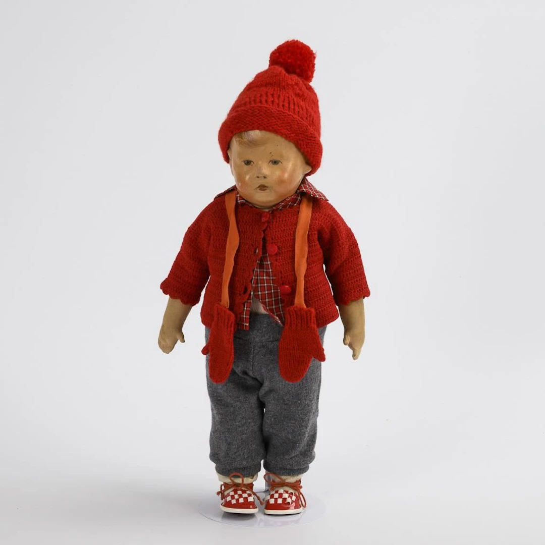 Boy doll with a red bobble hat. Käthe Kruse.