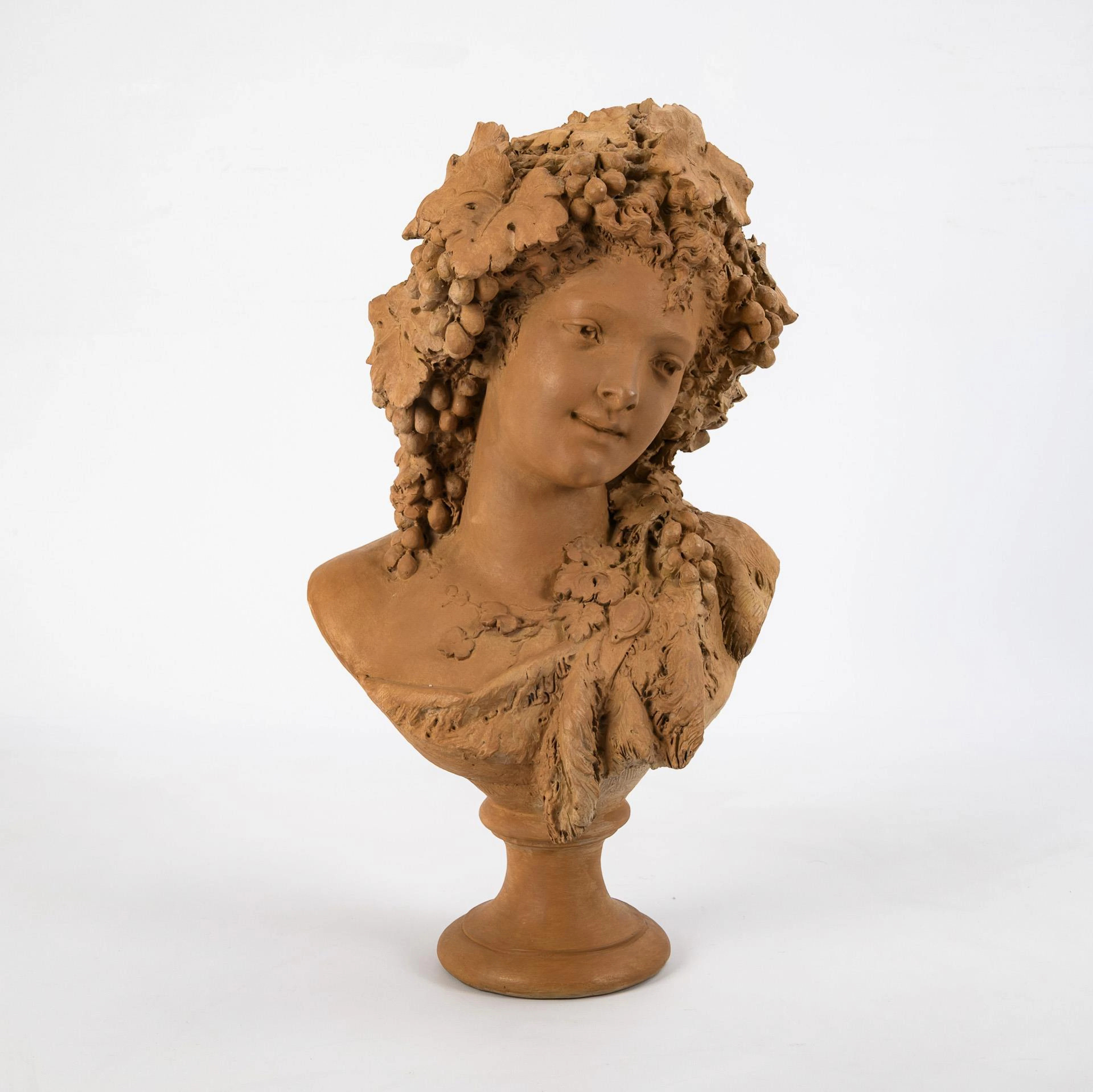 Female terracotta head with vine leaves.
