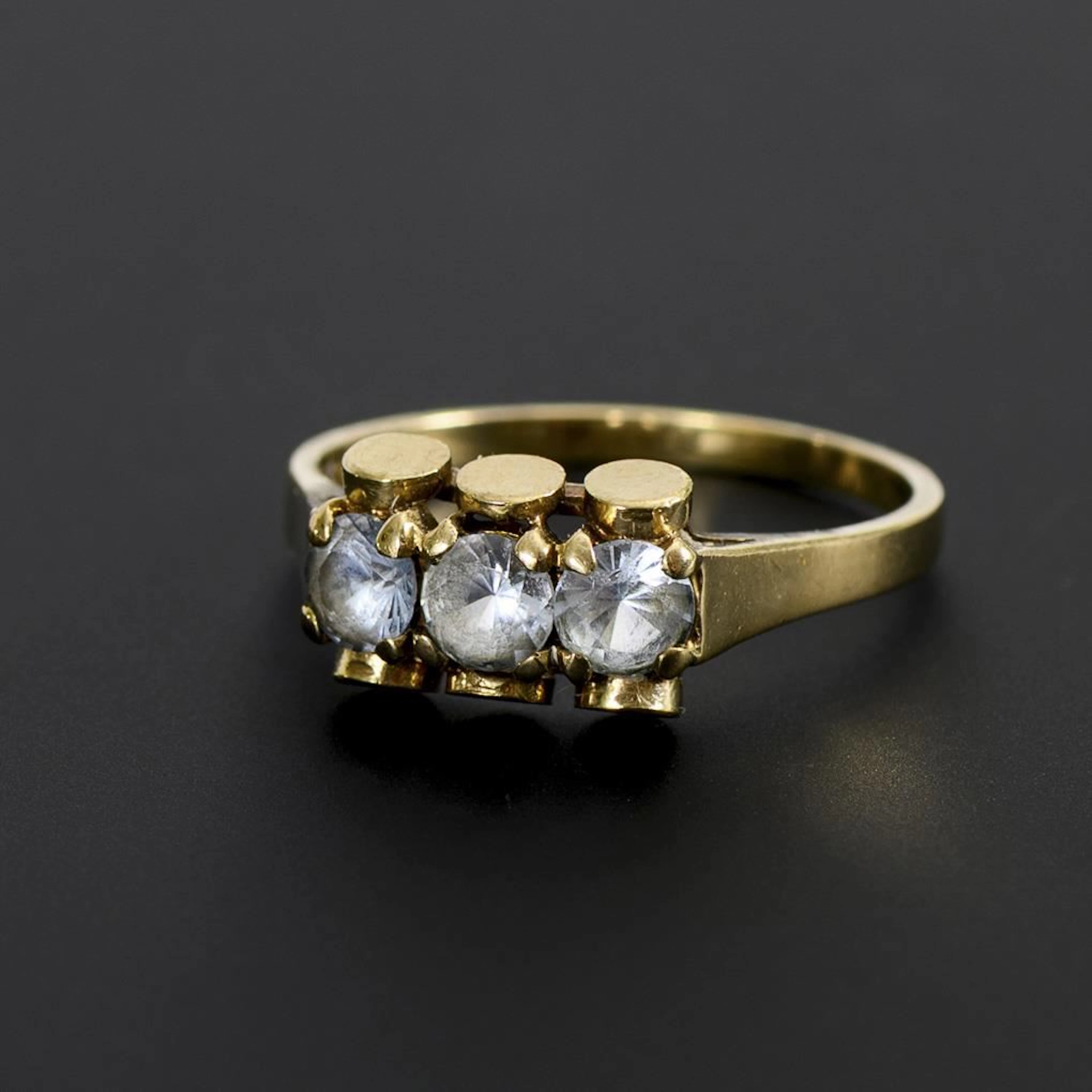 Modernist ring with 3 light blue gemstones.