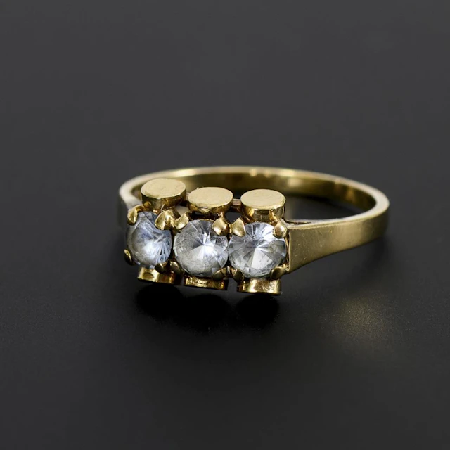 Modernist ring with 3 light blue gemstones.