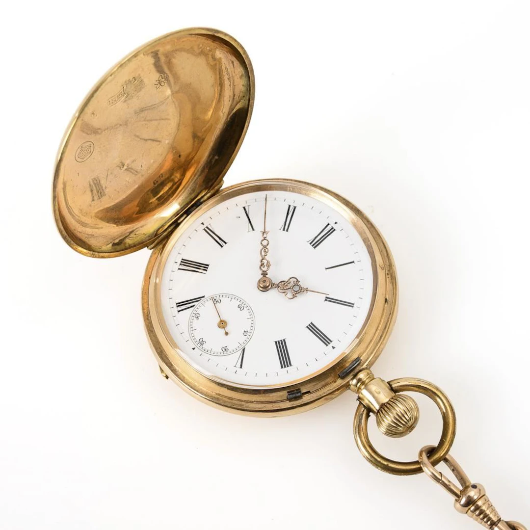 Gold savonnette with a gold watch chain.