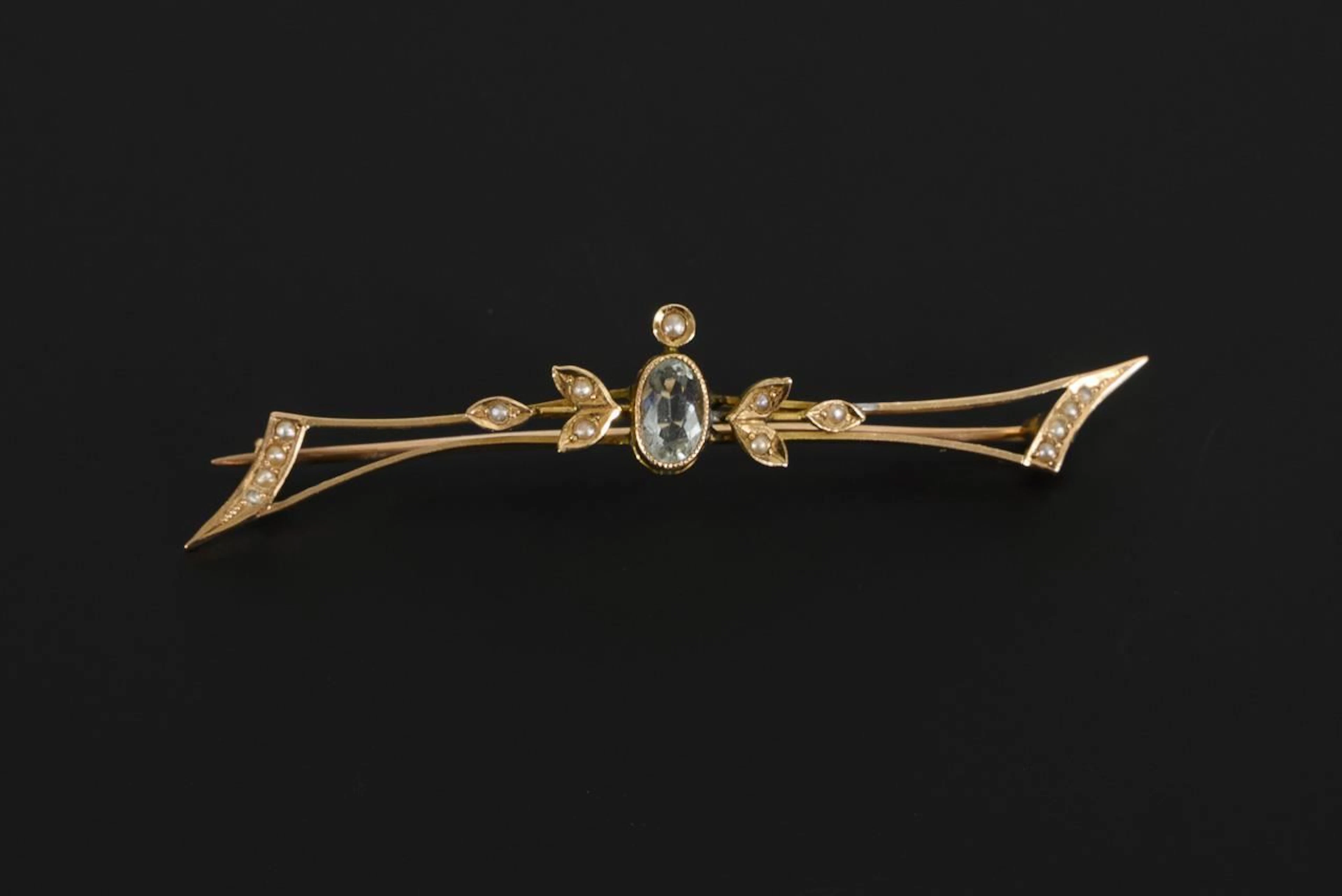 Art Nouveau brooch with a blue gemstone and seed beads.