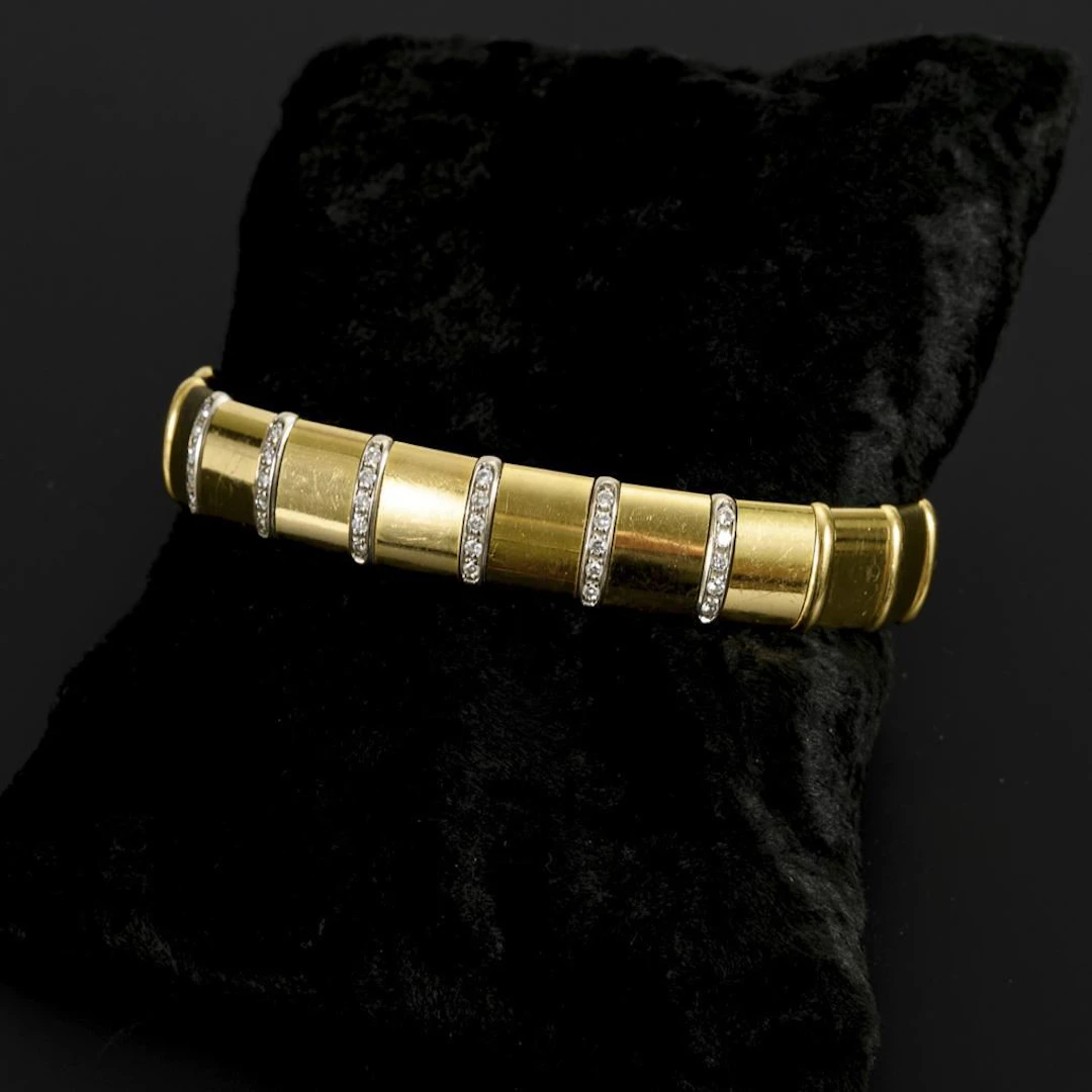 Two-tone bangle with bridges set with brilliant-cut diamonds.