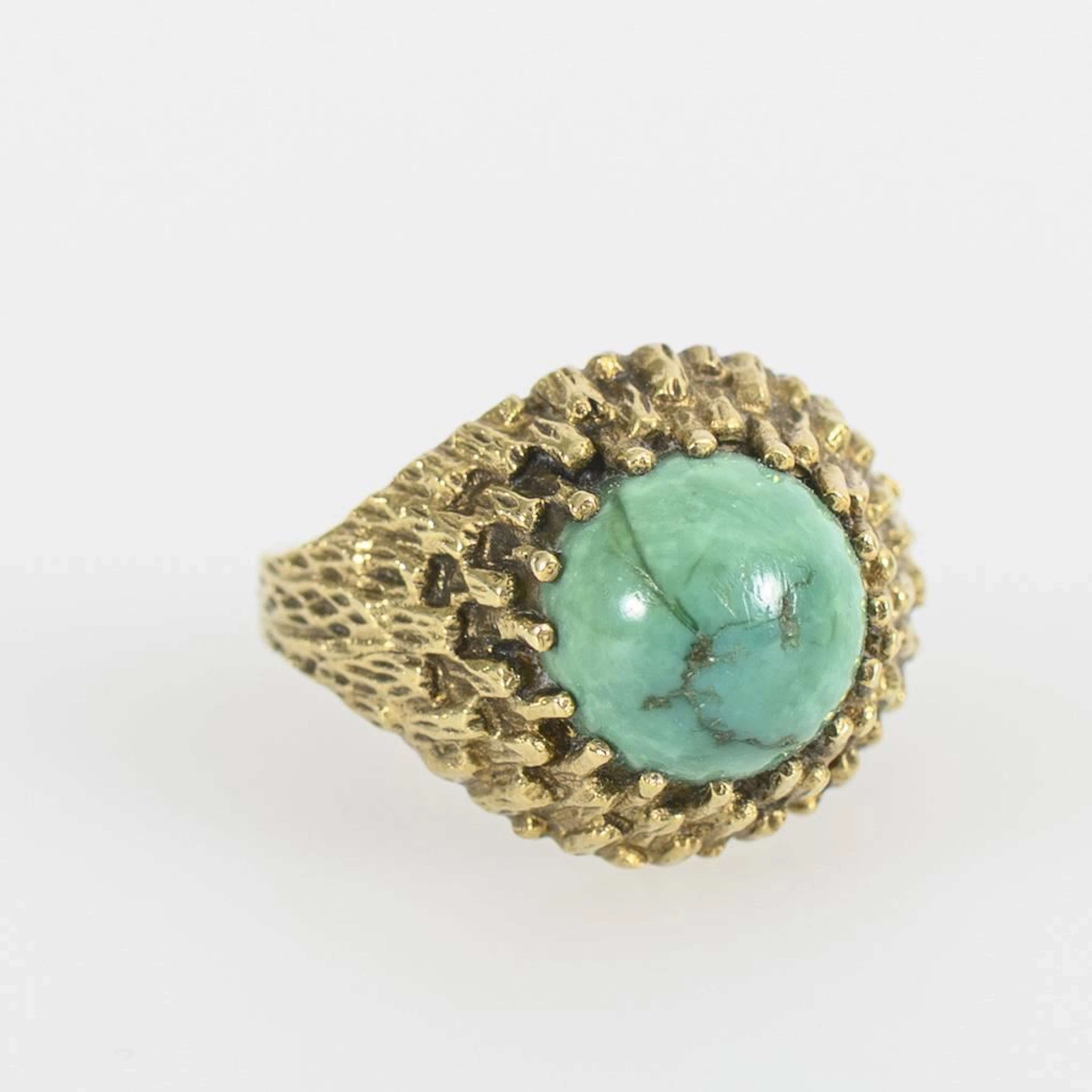 Modernist ring with a green cabochon stone.