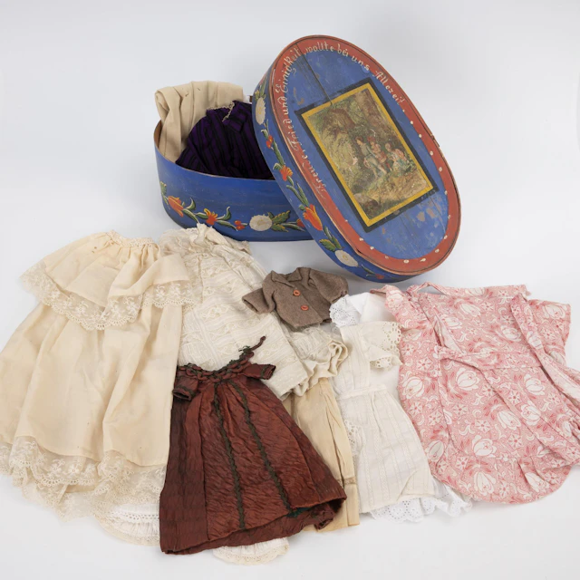Painted chipboard box with beautiful old doll's clothes.