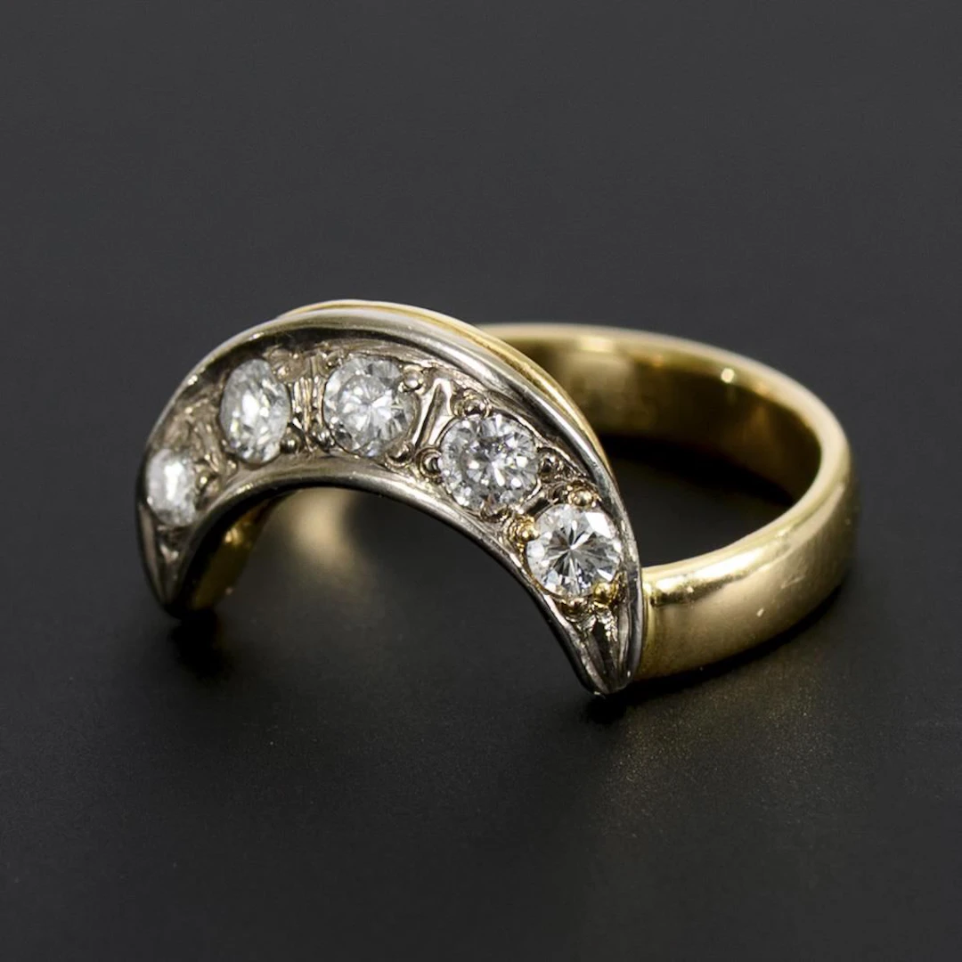 Crescent-shaped ring with old-cut diamonds.