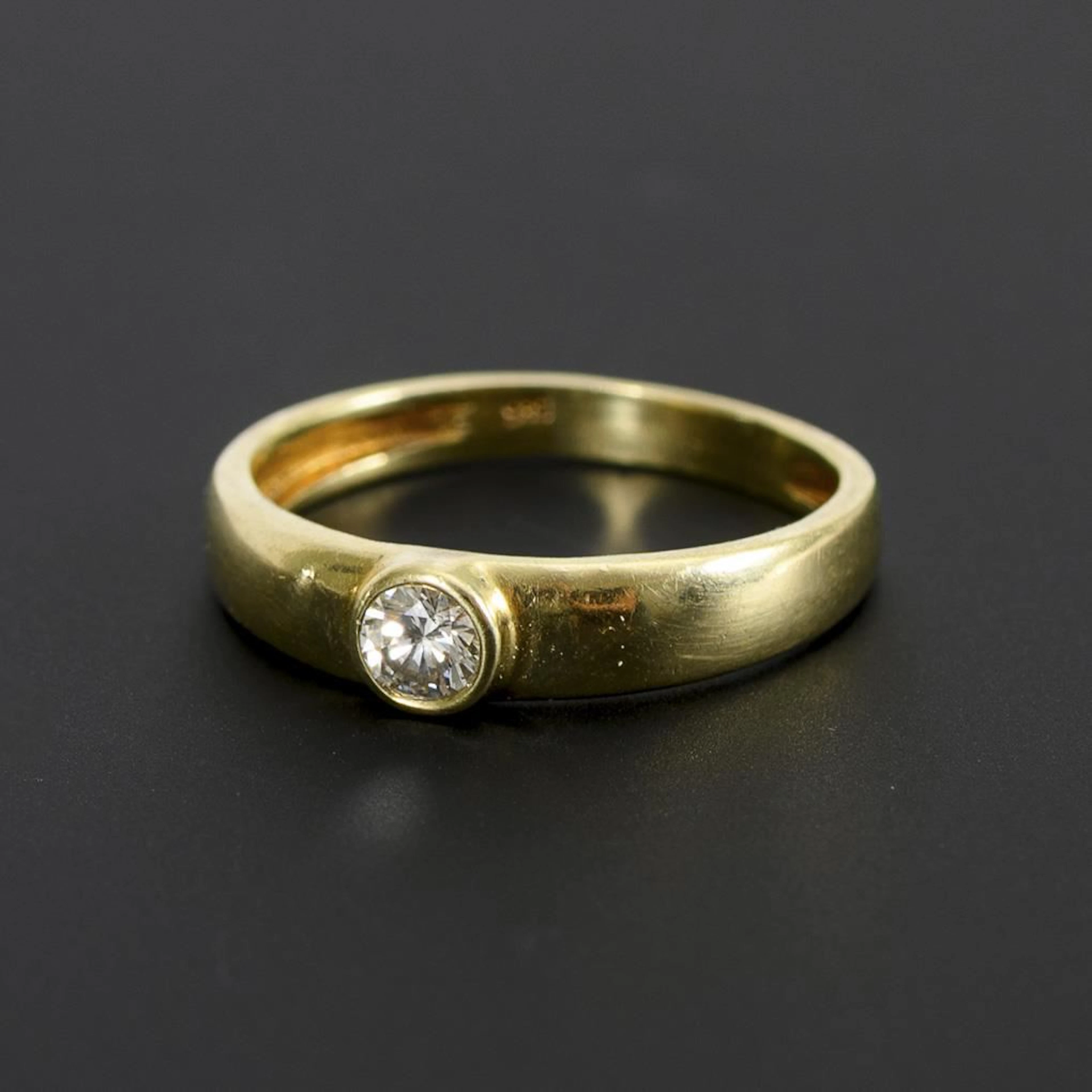 Ring with a solitaire brilliant-cut diamond.