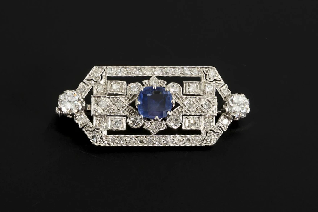 Art Deco-style brooch with brilliant-cut diamonds and a blue gemstone