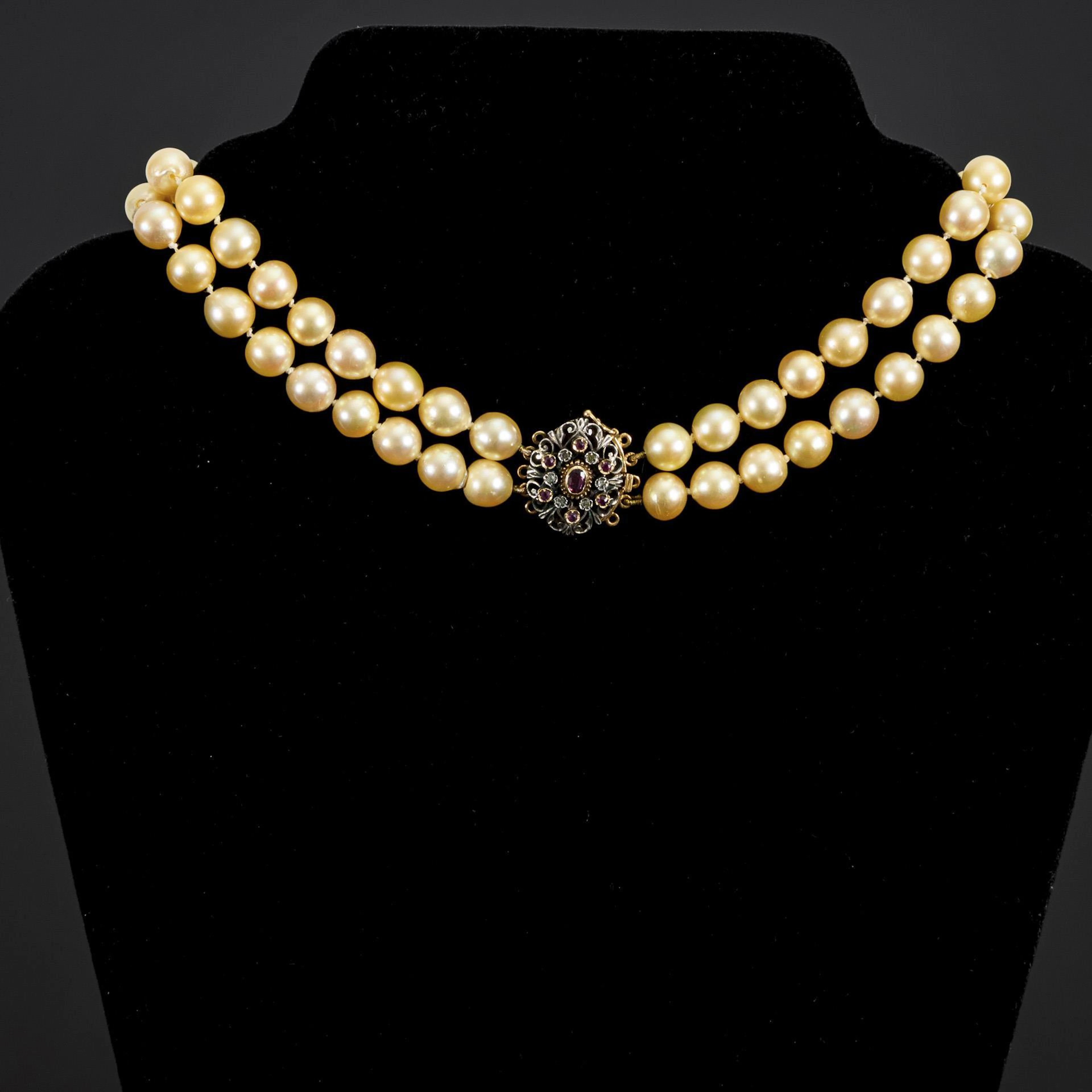 Double-row pearl necklace with decorative clasp.