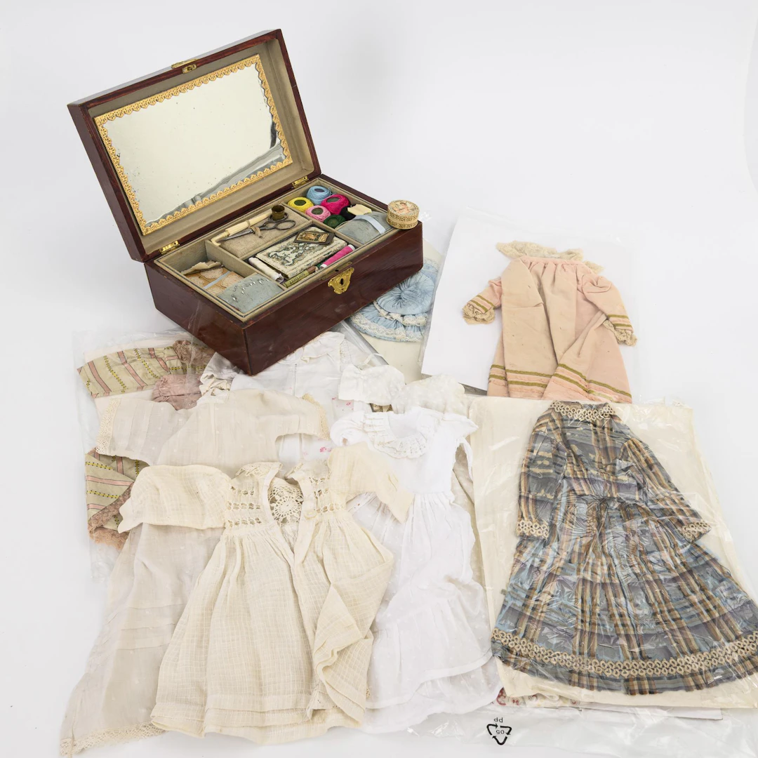 French sewing box, 9 old doll's dresses and blue hat.