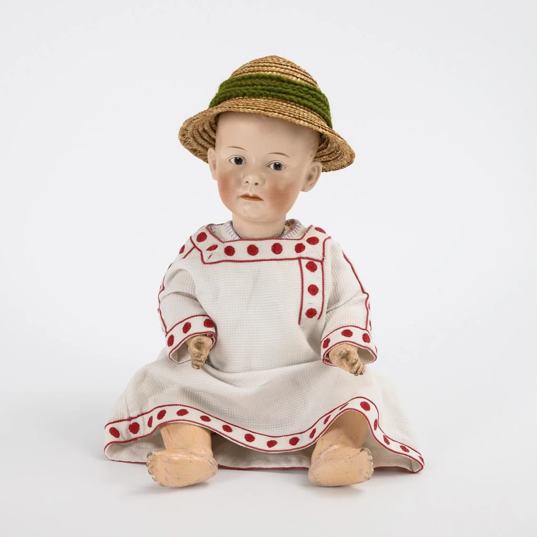 Full-head figurine of a boy wearing a straw hat. Heubach Brothers.