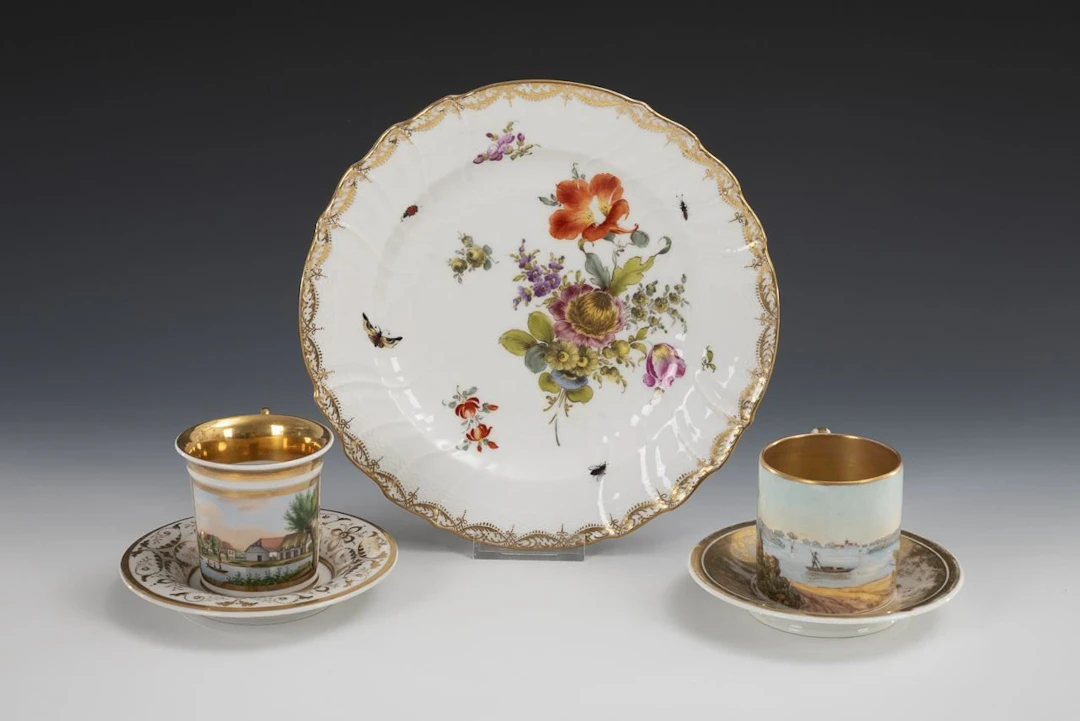 2 decorative cups and 1 plate with floral and insect motifs.