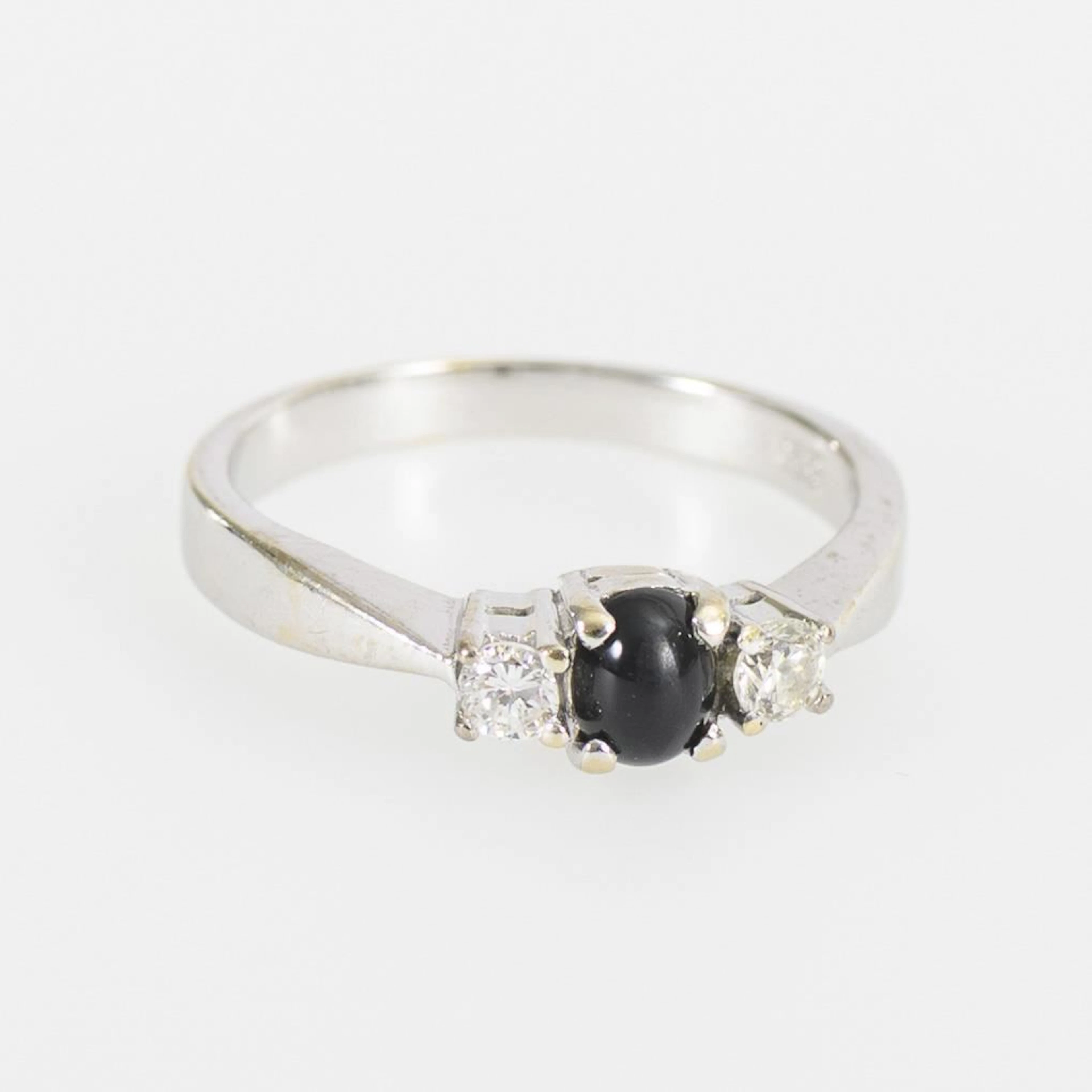 Ring with a blue cabochon gemstone, likely a sapphire, and 2 brilliant-cut