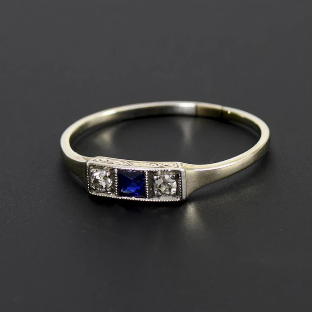 Art Deco ring featuring a trilogy of a blue gemstone, likely a sapphire