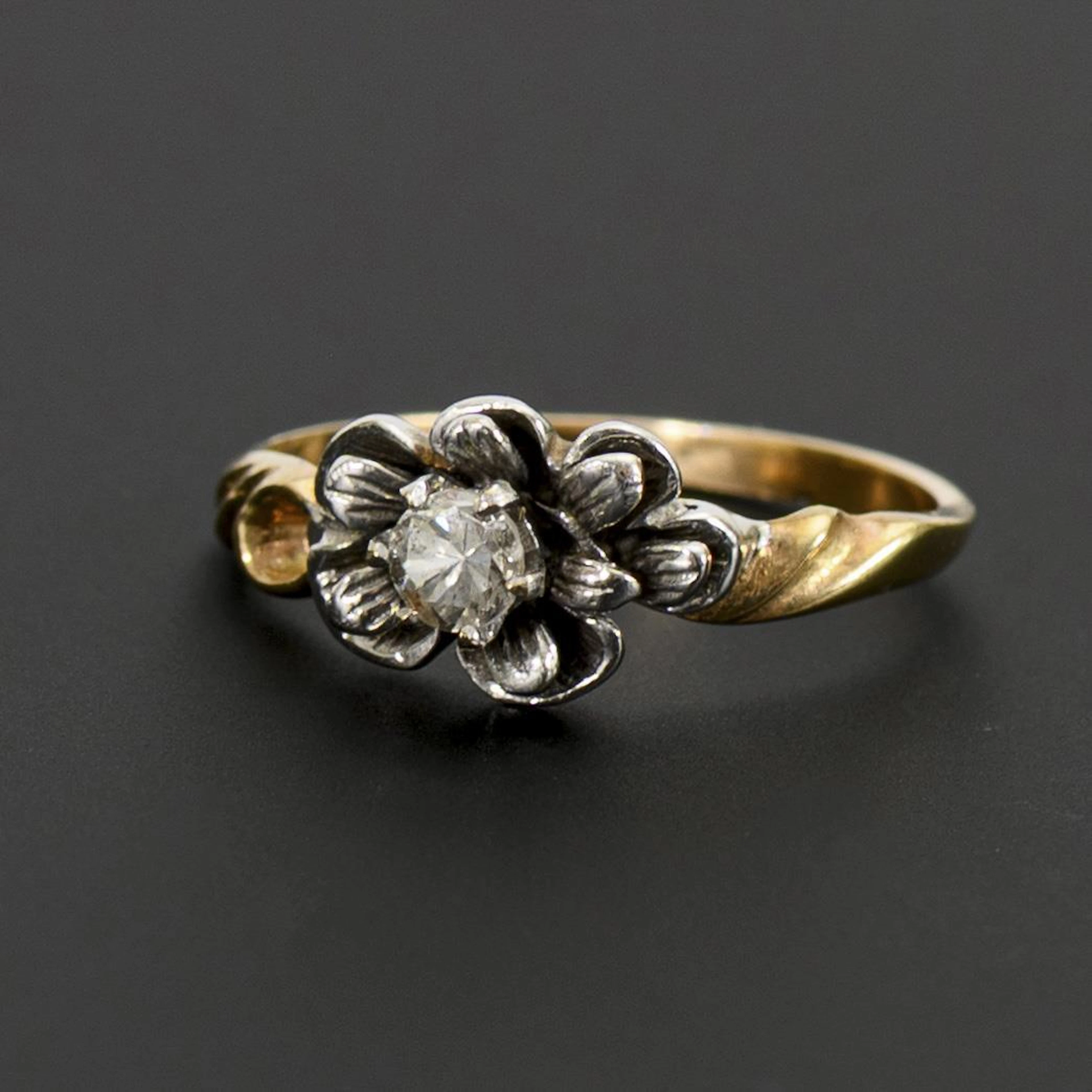 Ring with flower-shaped ring head and solitaire brilliant-cut diamond.