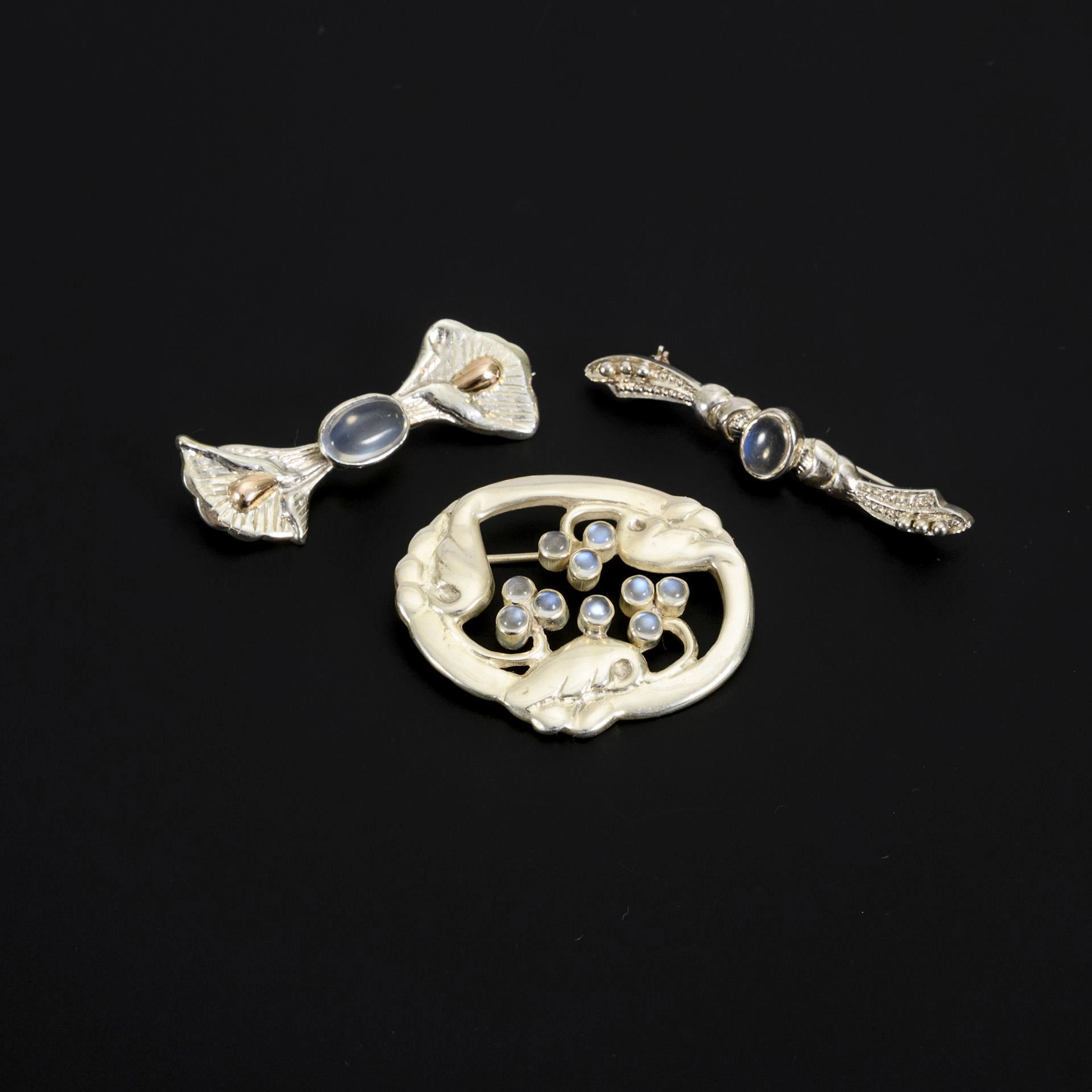 3 silver brooches with moonstones.