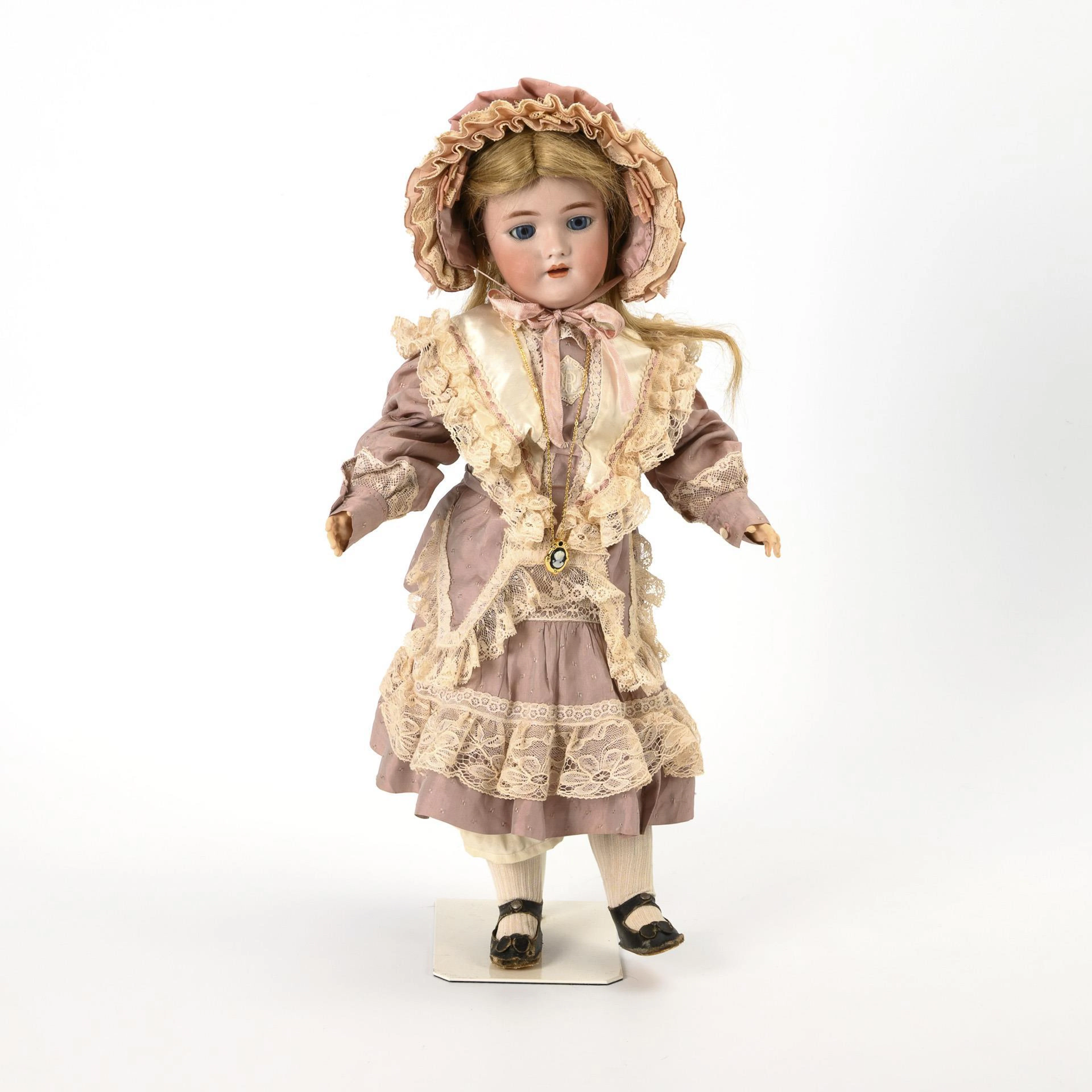 Blonde porcelain head doll in pink dress. Heinrich Handwerck.