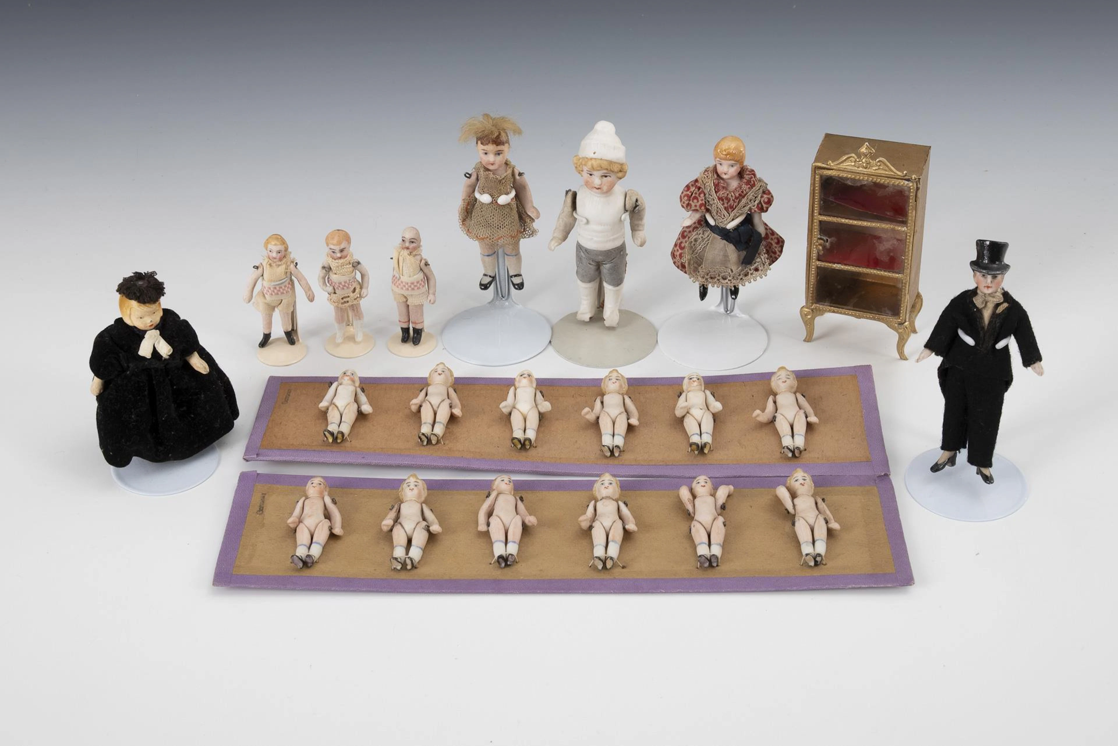 8 doll's house dolls, small display case and 2 sample plates with