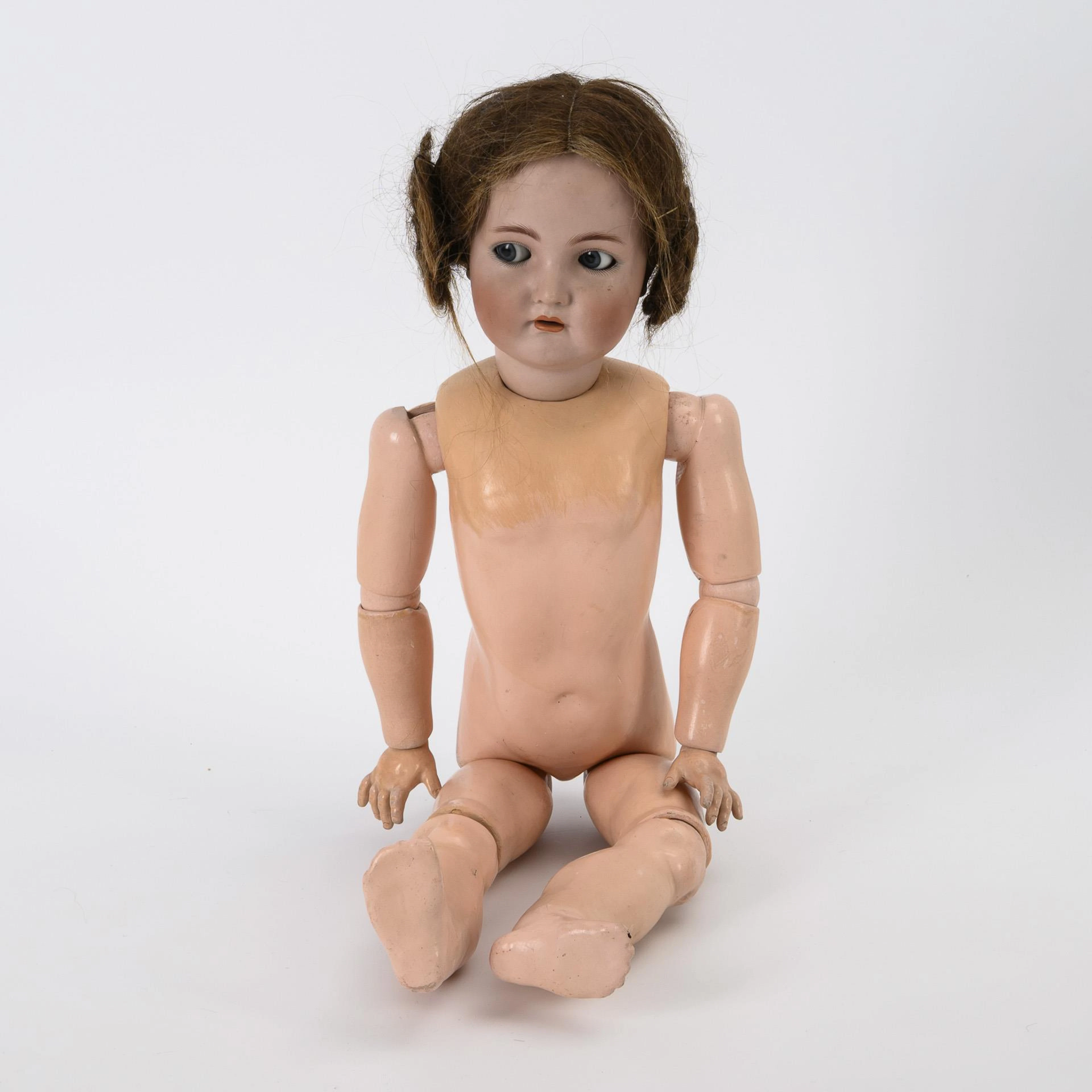 Unclothed porcelain head girl with snail hairstyle.
