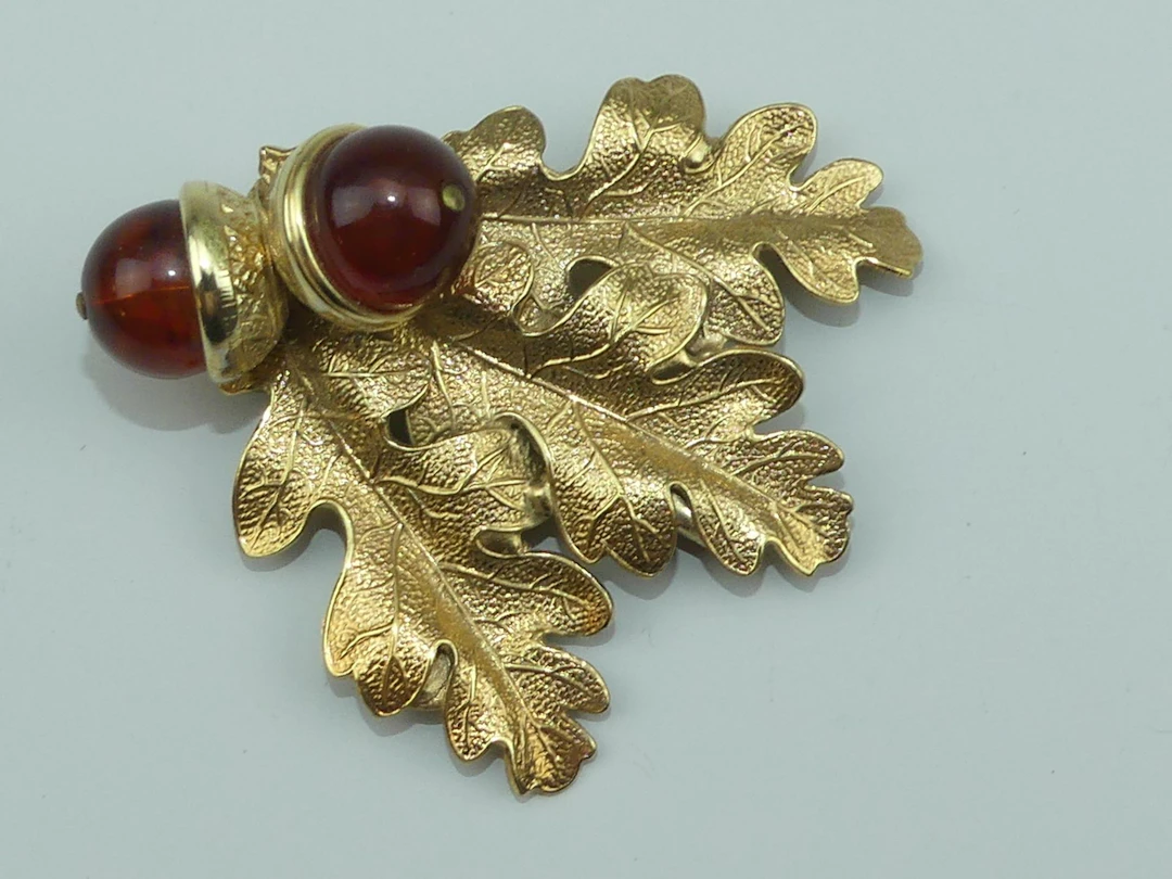 SAINT LUBIN. Broche en métal doré figurant une feuille de ch - Lot 456