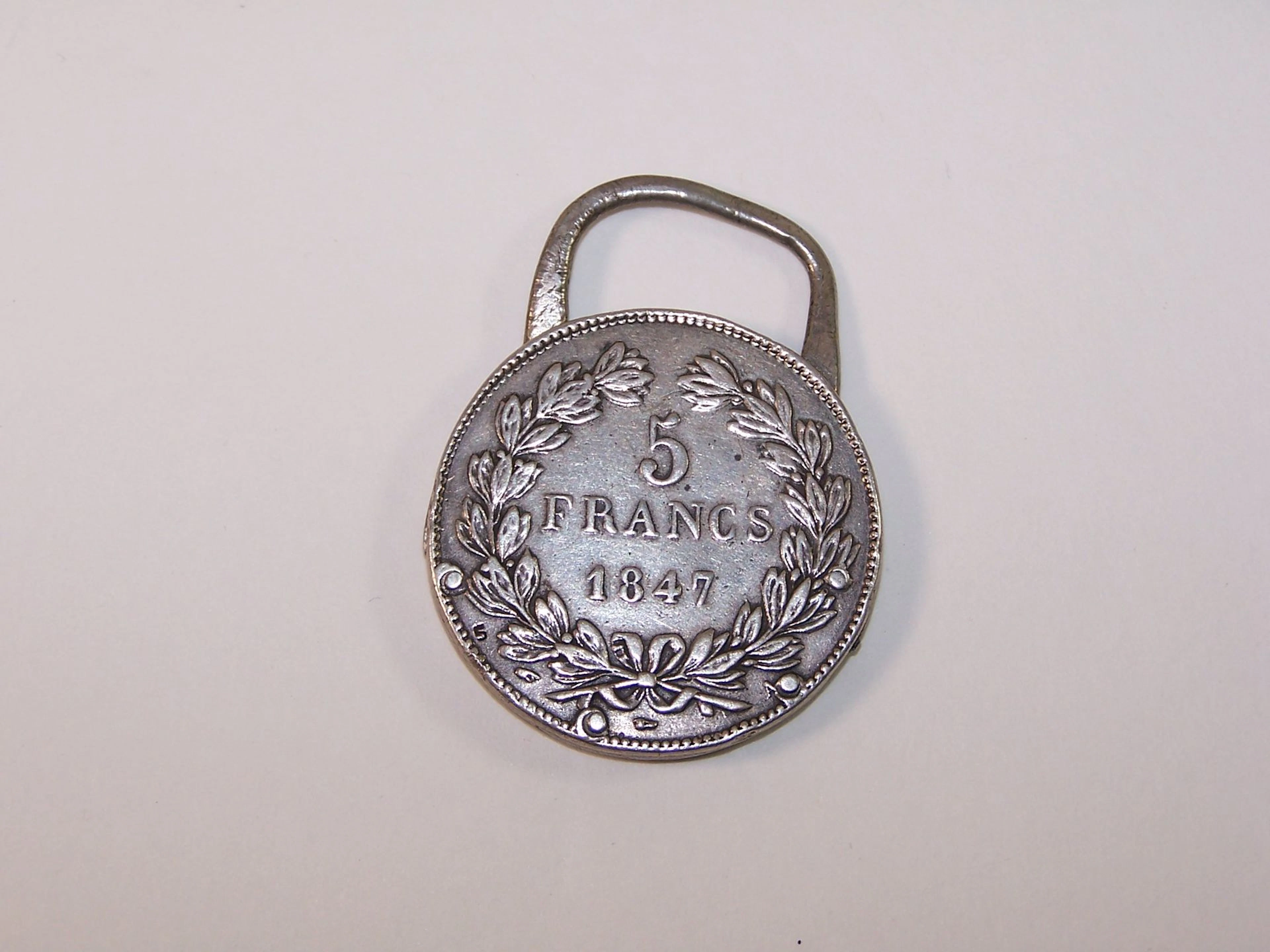 Porte clef / décapsuleur en argent min 800‰ dans une pièce - Lot 477
