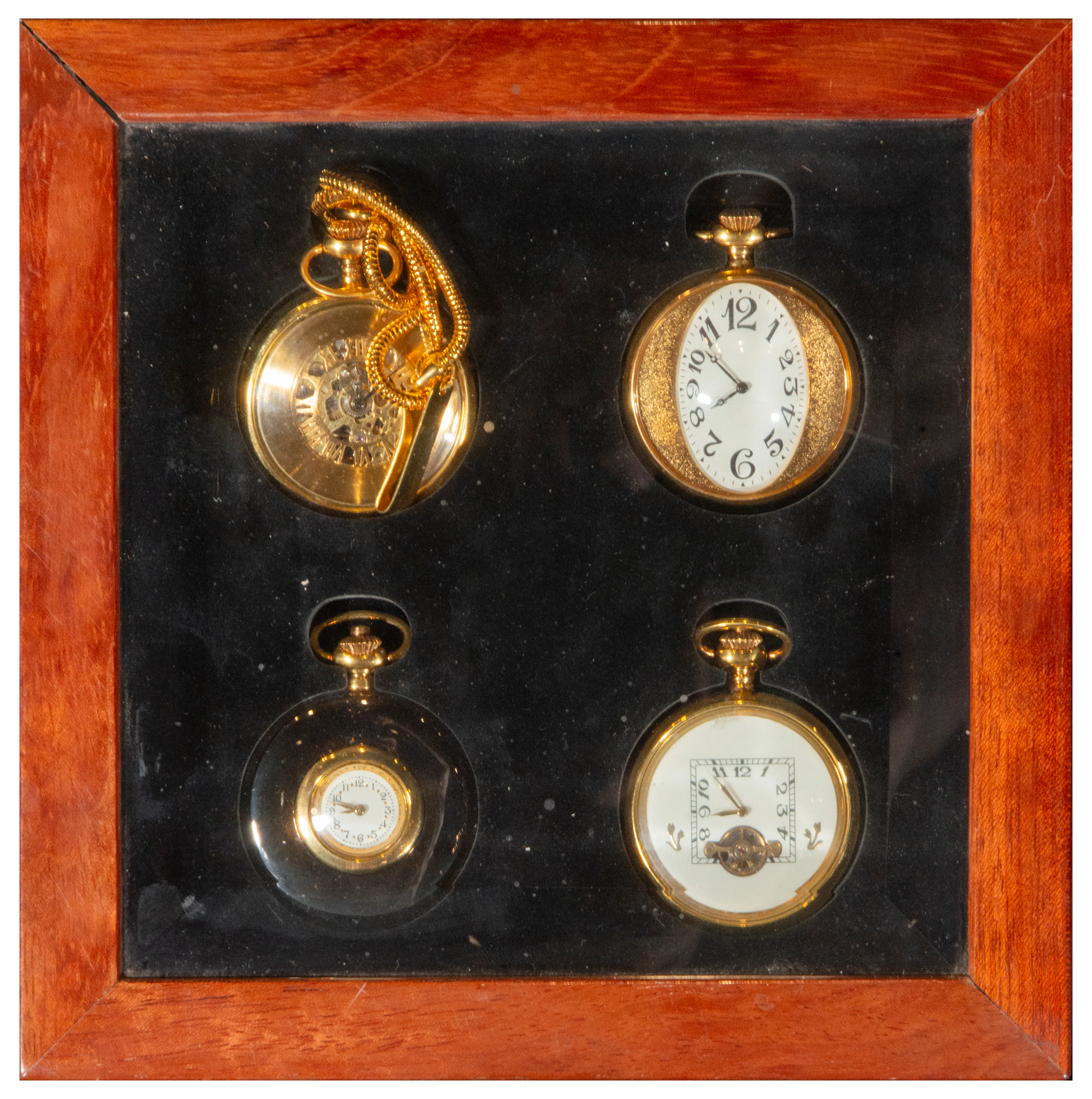 Set of four pocket watches in a wooden display case